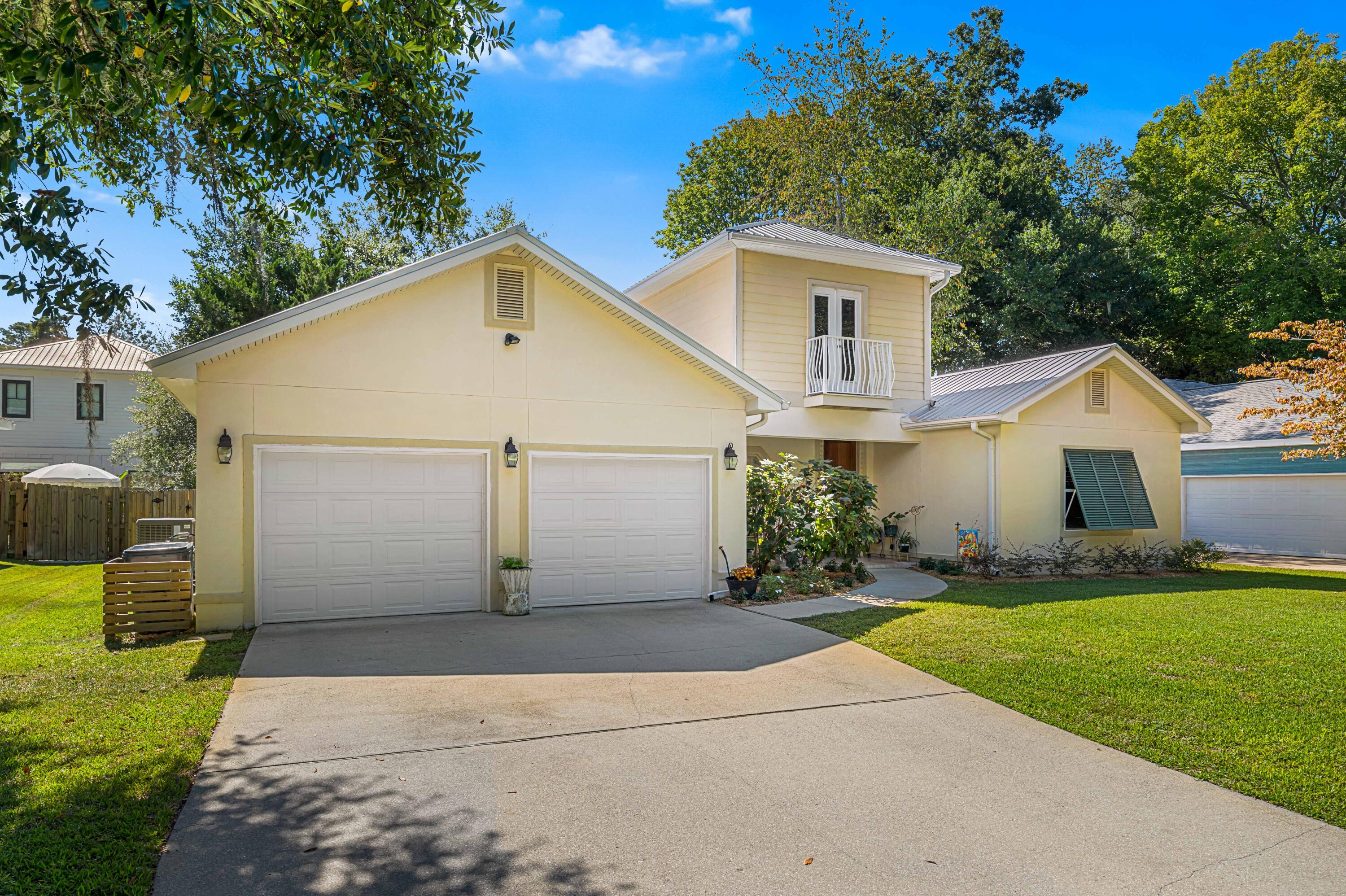 Tucked beneath a canopy of majestic oaks just steps from the bay, this beautifully crafted 4-bedroom, 3.5-bath home blends timeless Southern charm with thoughtful updates and inviting living spaces.

Step inside to discover a sun-drenched family room anchored by a cozy fireplace, where oversized windows frame views of the lush courtyard beyond. The open floor plan flows seamlessly into the gourmet kitchen, showcasing granite countertops, rich cherry cabinetry, full granite backsplash, and a breakfast bar ideal for casual meals or morning coffee. Designed for modern living, the home features two primary suites on the main leveloffering exceptional flexibility for multi-generational families or guests seeking privacy. The luxurious primary retreat includes a double vanity, jetted soaking tub, and separate walk-in shower. Upstairs, two additional bedrooms share a full bath, both featuring charming Juliette balconies perfect for savoring morning breezes.

Quality craftsmanship shines throughout: a solid mahogany front door, crown molding, classic Bermuda shutters, and a new metal roof ensure both beauty and durability. Outside, the property truly captivates with professionally landscaped grounds, a fenced backyard, and a New Orleans-style gated courtyard complete with fountainan enchanting space for al fresco dining or quiet relaxation.

The generous lot provides room to roam, while the two-car garage features a separate workshop and walk-in attic storage for all your needs. Nestled near Mack Bayou, this peaceful retreat offers Old Florida tranquility yet remains minutes from Ascension Sacred Heart Hospital, Grand Boulevard's vibrant shopping and dining and the sugar-white beaches of the Emerald Coast.