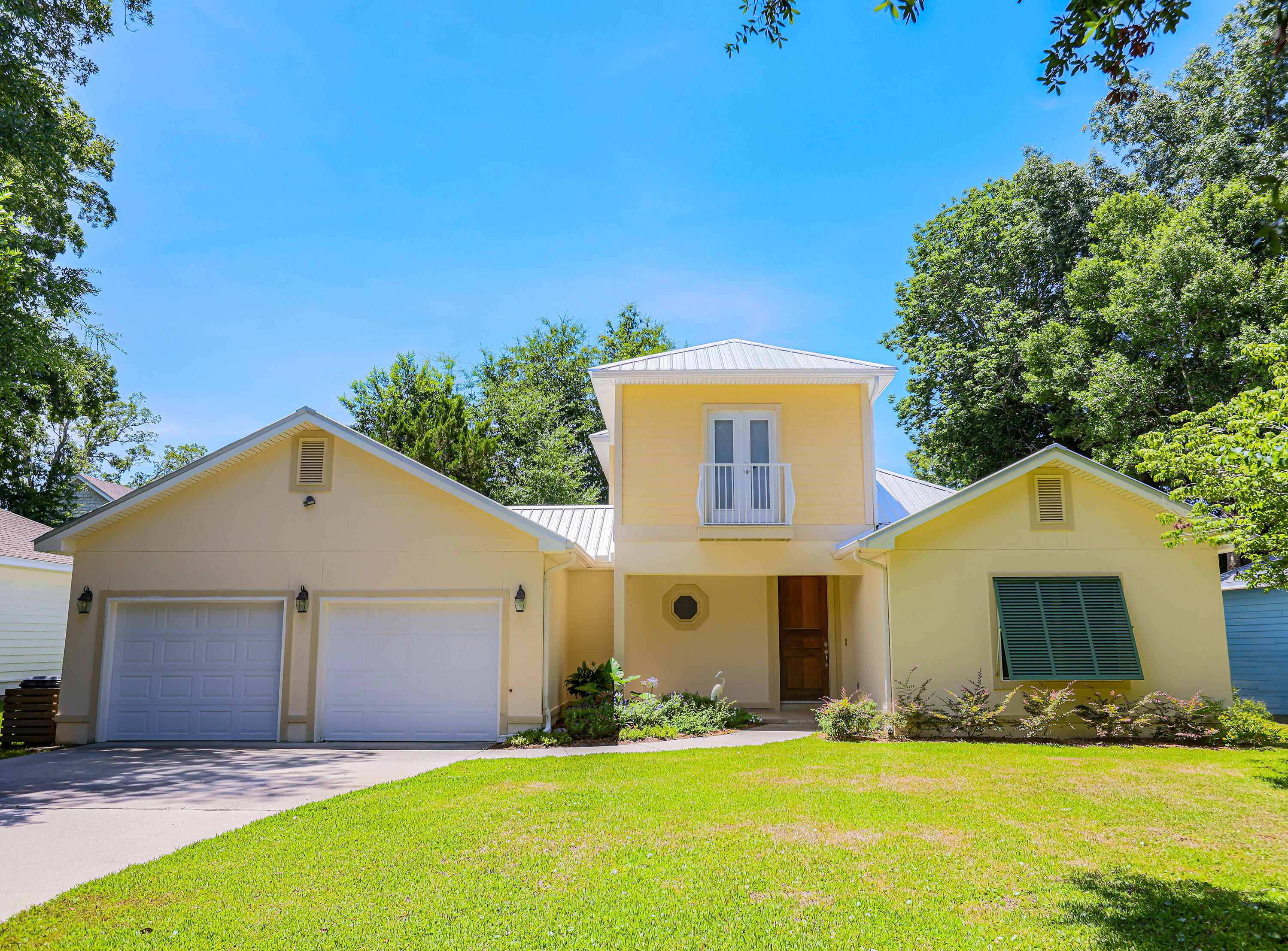 NEW METAL ROOF INSTALLED AUGUST 2025!! Tucked beneath a canopy of majestic oaks just steps from the bay, this beautifully crafted 4-bedroom, 3.5-bath home blends timeless Southern charm with thoughtful updates and inviting living spaces.

Step inside to discover a sun-drenched family room anchored by a cozy fireplace, where oversized windows frame views of the lush courtyard beyond. The open floor plan flows seamlessly into the gourmet kitchen, showcasing granite countertops, rich cherry cabinetry, full granite backsplash, and a breakfast bar ideal for casual meals or morning coffee. Designed for modern living, the home features two primary suites on the main leveloffering exceptional flexibility for multi-generational families or guests seeking privacy. The luxurious primary retreat includes a double vanity, jetted soaking tub, and separate walk-in shower. Upstairs, two additional bedrooms share a full bath, both featuring charming Juliette balconies perfect for savoring morning breezes.

Quality craftsmanship shines throughout: a solid mahogany front door, crown molding, classic Bermuda shutters, and a new metal roof ensure both beauty and durability. Outside, the property truly captivates with professionally landscaped grounds, a fenced backyard, and a New Orleans-style gated courtyard complete with fountainan enchanting space for al fresco dining or quiet relaxation.

The generous lot provides room to roam, while the two-car garage features a separate workshop and walk-in attic storage for all your needs. Nestled near Mack Bayou, this peaceful retreat offers Old Florida tranquility yet remains minutes from Ascension Sacred Heart Hospital, Grand Boulevard's vibrant shopping and dining and the sugar-white beaches of the Emerald Coast.