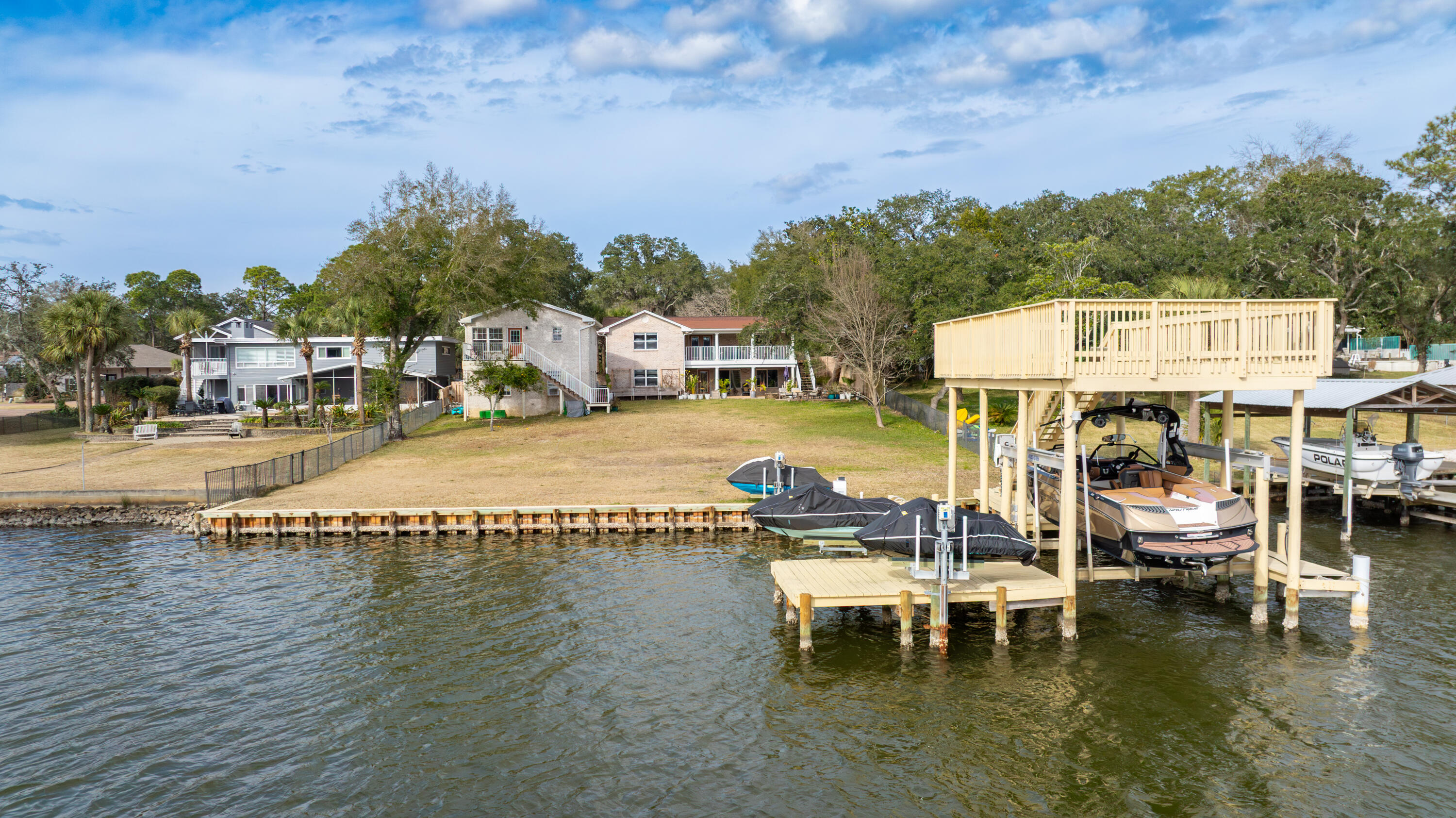 Experience exceptional waterfront living on this rare deep-water property, perfectly positioned on a spacious 0.66-acre lot. This all-brick residence, complete with a separate guest carriage house, offers breathtaking water views, direct Gulf access, and an unbeatable location just minutes from shopping, dining, VPS Airport, Fort Walton Beach Medical Center, Hurlburt Field, and Eglin Air Force Base. Thoughtfully updated, recent improvements include a new boat lift and ski lifts, fresh interior paint, a tankless water heater, updated lighting, new landscaping, and newly constructed stairs for both the rear deck and carriage house. The home was completely renovated in 2006, taken down to the studs and rebuilt with new plumbing, electrical systems, and high-quality finishes throughout. The main home features three bedrooms and two-and-a-half baths on the upper level. The lower level provides additional living space with a fourth bedroom, full bath, expansive family room, and a cozy wood-burning fireplace. Above the garage, the private carriage house offers a one-bedroom, one-bath layout complete with a living room and full kitchen, making it ideal for guests, extended family, or rental opportunities. Combining deep-water access, expansive outdoor space, and a beautifully maintained interior, this remarkable property embodies the very best of waterfront living. while the lower level includes an additional bedroom, full bath, spacious living room and wood burning fireplace. Above the garage you'll find a 1 bed/1 bath carriage house with living room and full kitchen. With its deep-water access, expansive grounds and beautifully maintained interior, this property captures the essence of waterfront living at its finest.