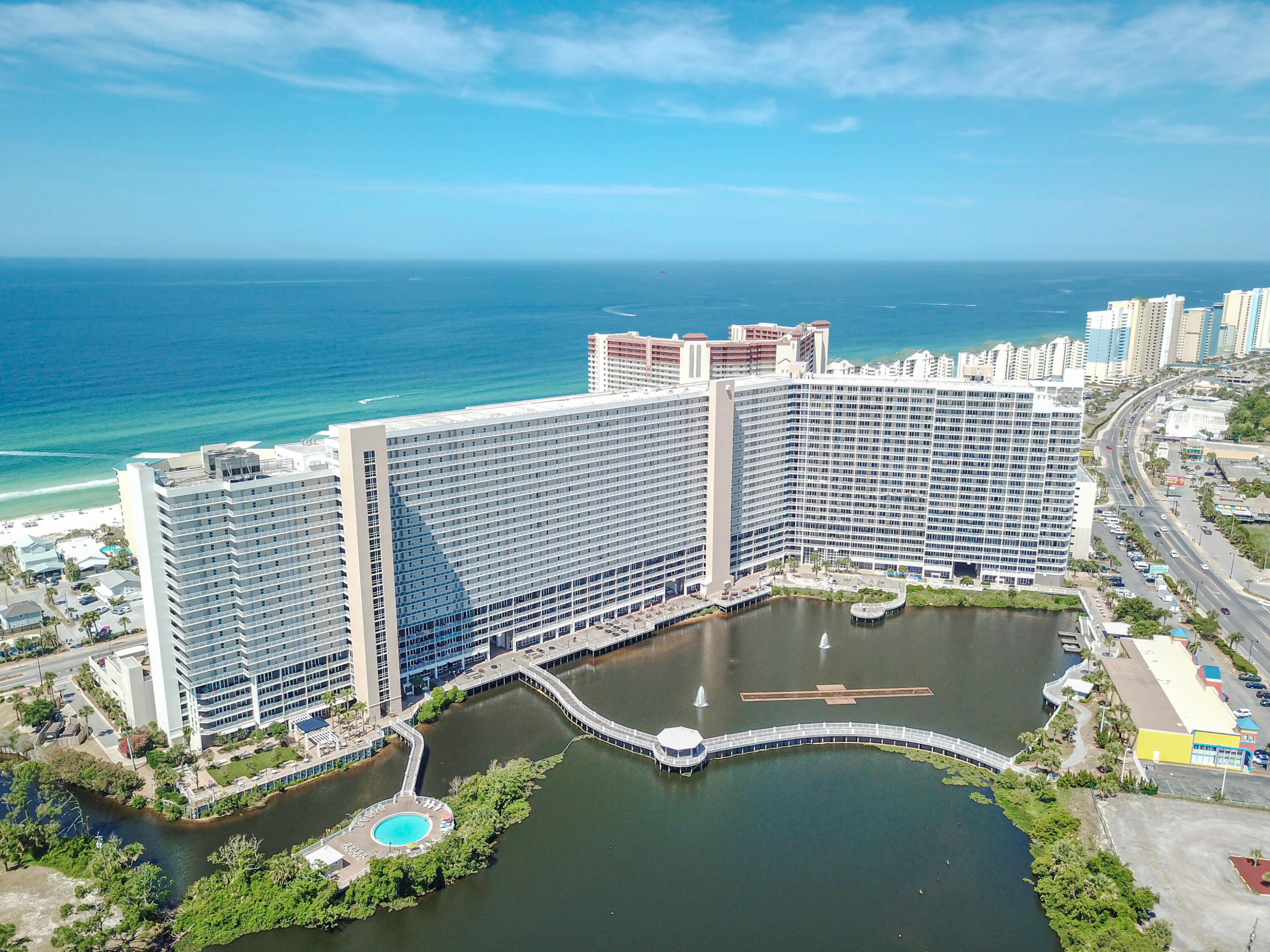 Welcome to Laketown Wharf! This beautifully furnished 2-bedroom + bunk room, 2-bath condo is located on the 19th floor and offers over 1,260 square feet of spacious living. Enjoy an oversized private balcony overlooking the resort's lake, boardwalk, pools, and nightly fountain show, with Gulf views from the front bedrooms. Recent updates include new carpet, fresh paint, and newer kitchen appliances. Laketown Wharf offers resort-style amenities including multiple pools, hot tubs, fitness center, restaurants, beach access just across the street, and entertainment for the whole family. Whether you're looking for a primary residence, vacation getaway, or income-producing investment, this turnkey condo is ready to enjoy!