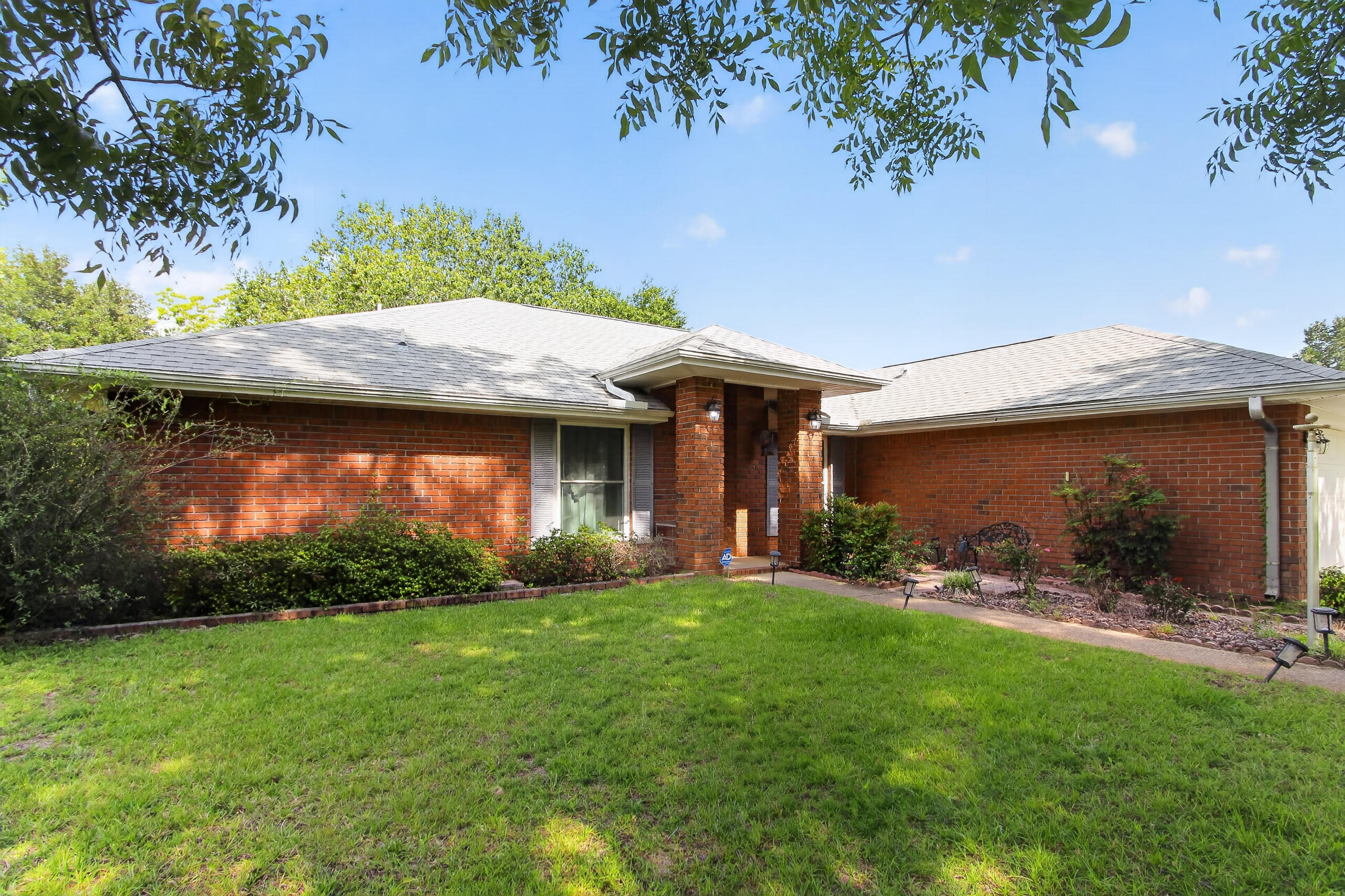 4-bedroom, 2-bath brick home offers comfort, space, and unbeatable amenities just minutes from Navarre Beach, shopping, and top-rated schools. Featuring a split floor plan for privacy, the home includes an eat-in kitchen with breakfast bar and pantry, a formal dining room, a dedicated office, and a cozy gas fireplace in the living room. Enjoy recent upgrades such as new impact windows, a new roof, newer HVAC and hot water heater, a 3-year-old whole-house propane generator, and a hurricane-rated garage door with a 220V outlet. Flooring updated with LVP in living room, guest bedroom and dining room. The screened back porch and large patio with built-in gas grill overlook a level, tree-lined backyard with plenty of room to relax or entertain.  A standout feature is the 15x27 insulated workshop/studio with its own electrical panel ideal for hobbies, storage, or creative use.