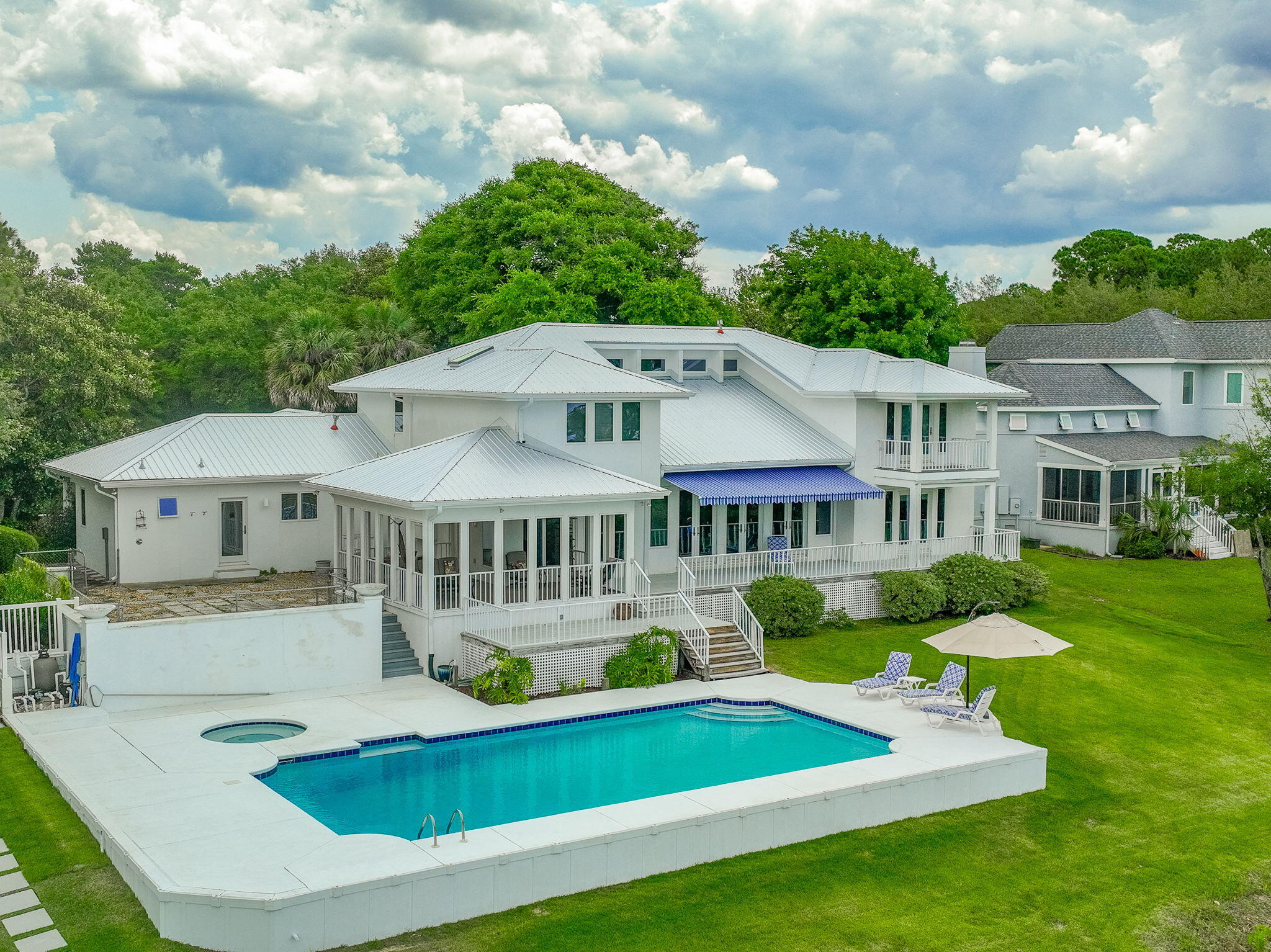 Your Paradise on the Point awaits! This newly updated & meticulously maintained, custom home is nestled on a private, 1 acre cul-de-sac lot with 200 waterfront feet on Santa Rosa Sound. Enjoy uniquely spectacular sunsets & panoramic views of the Santa Rosa Sound, Intercoastal Waterway & Navarre Beach skyline from the newly built dock & boat house. The new metal roof, hvac and hot water heater affords comfort and worry free living! Fall in love with life on 'the point.' Breathtaking outdoor spaces include mature landscape as well as covered & open patios. This is your private waterfront oasis. Enjoy a spectacular view from the ground floor primary suite balcony and take a dip in the pool or spa. Soaring ceilings & large, full view windows & doors welcome you to bright, light, open living