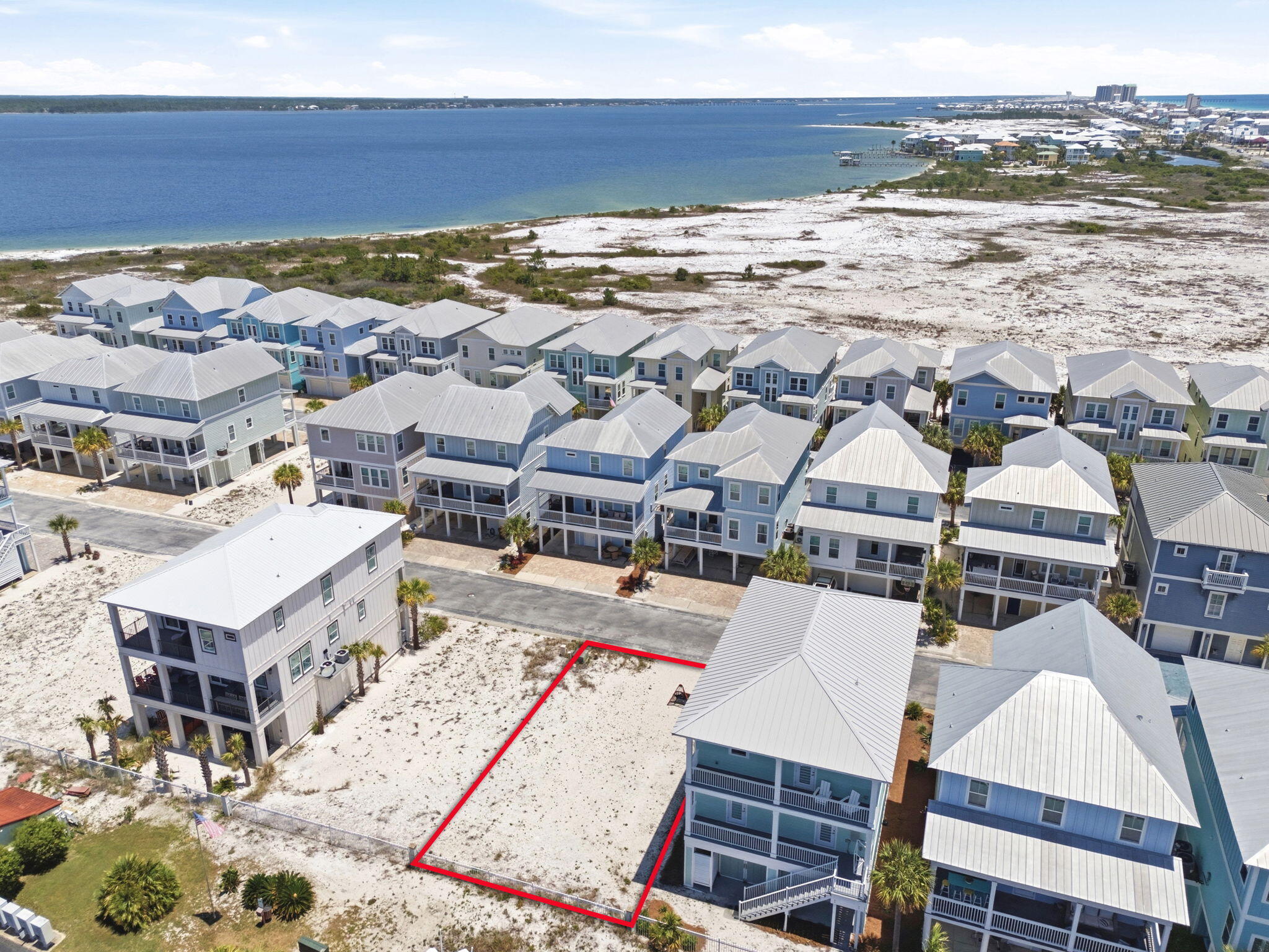 Welcome to one of the few gated communities on beautiful Navarre Beach, where coastal luxury and laid-back island living come together perfectly. This prime homesite is 100% buildable and ready for your dream beach house, whether you envision a full-time waterfront retreat, second home, or income-producing vacation rental property.

Inside the gated entrance, residents enjoy access to a community pool and charming gazebo area...perfect for relaxing afternoons, entertaining guests, or unwinding after a day on the water. Just a short stroll away, sink your toes into Navarre Beach's famous sugar-white sand and emerald waters. Spend your days watching dolphins swim by, boats cruise the Sound, parasailers soaring overhead, and jet skiers enjoying the coastline. (Might I add, fireworks on 4th of July easily seen here) 
For boating and fishing enthusiasts, nearby Juana's offers a convenient public boat launch, making it easy to enjoy everything the Gulf Coast lifestyle has to offer. Many owners love cruising the island by golf cart, embracing the relaxed beach-town atmosphere that makes Navarre Beach so special.
Once your future elevated home is complete, you'll capture breathtaking panoramic water views from multiple levels. And directly across from the gated entrance, you'll find immediate access to the Gulf side of Navarre Beach -- known for its turquoise waters, rolling waves, and postcard-worthy sunsets. Navarre Beach remains one of Florida's hidden gems, attracting visitors year after year for its natural beauty, peaceful atmosphere, and strong vacation rental demand. Surrounded by multimillion-dollar beach homes, this lot presents an incredible opportunity at an attractive price point for buyers looking to build now or invest in the future.

Build your coastal vision here and experience why so many families fall in love with Navarre Beach year after year.

Contact an agent for the documents and HOA disclosure so you know how to design your next build this year.