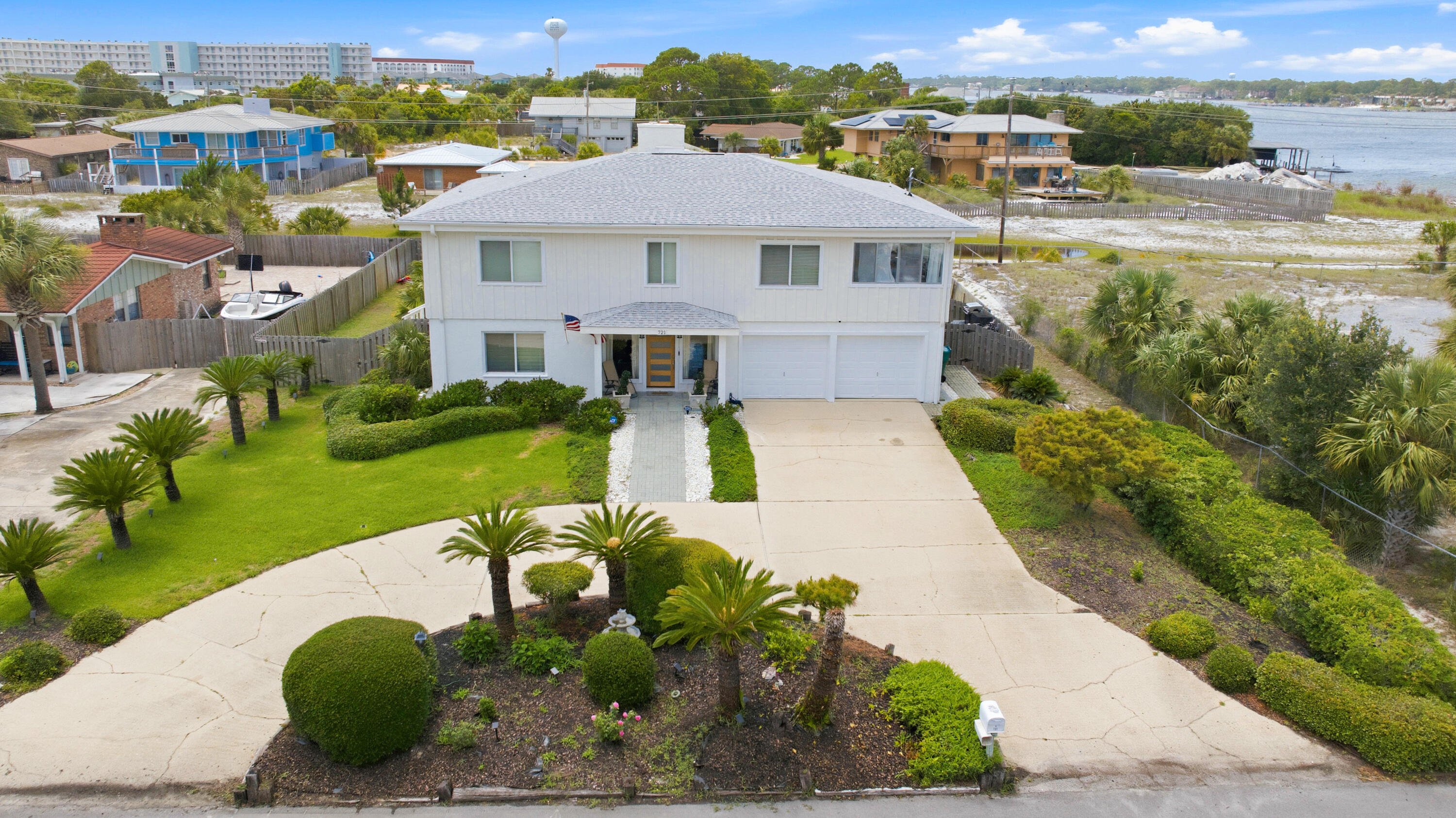 New Exterior Painted Water View Home. Steps to the Sound. Moments to the Beach. A thoughtfully designed mid-century, coastal home on highly sought-after Okaloosa Island. Located just steps from direct Intracoastal Sound water access and a short 3-minute walk to Public Beach Access 6, 721 Sailfish Drive offers an exceptional Florida coastal lifestyle. This expansive 5-bedroom, 3-bath home features Sound views, a remodelled atrium space, and enclosed sunrooms with oversized front-facing windows that bring in abundant natural light, including a cardio/fitness room and a coffee bar with water views.

The open floor plan is designed for both everyday living and entertaining, highlighted by two elegant double-flue fireplaces with white marble rock surrounds that add warmth and architectural balance. A redesigned floating staircase with custom iron detailing creates a strong first impression, complemented by Vermont slate tile, newly installed LVP flooring (2025), cypress wood walls, new lighting and ceiling fans, and custom window treatments.

The updated kitchen includes brand-new stainless-steel appliances (2024), a double pantry, breakfast bar, eat-in dining area, vast water views and seamless flow into the main living spaces. The primary suite is a true retreat, offering Sound water views, private access to a covered deck, a cedar-lined walk-in closet, and a fully renovated ensuite bathroom with a custom tile walk-in rain shower, frameless glass door, LED backlit mirror, and upgraded fixtures.

Two distinct levels of living space provide flexibility for entertaining, hosting, or multigenerational living, with a lower-level living area and wet bar with kitchenette components that work well for guests or in-laws. Outdoors, the home offers a fenced-in oversized pool, covered patio, expansive back deck with screening potential, outdoor shower, and newly installed St. Augustine sod (2025). Elevated at 12'6" above sea level, the home offers peace of mind while delivering a lifestyle tailored for beach lovers, entertainers, and families seeking water views and effortless Gulf access.