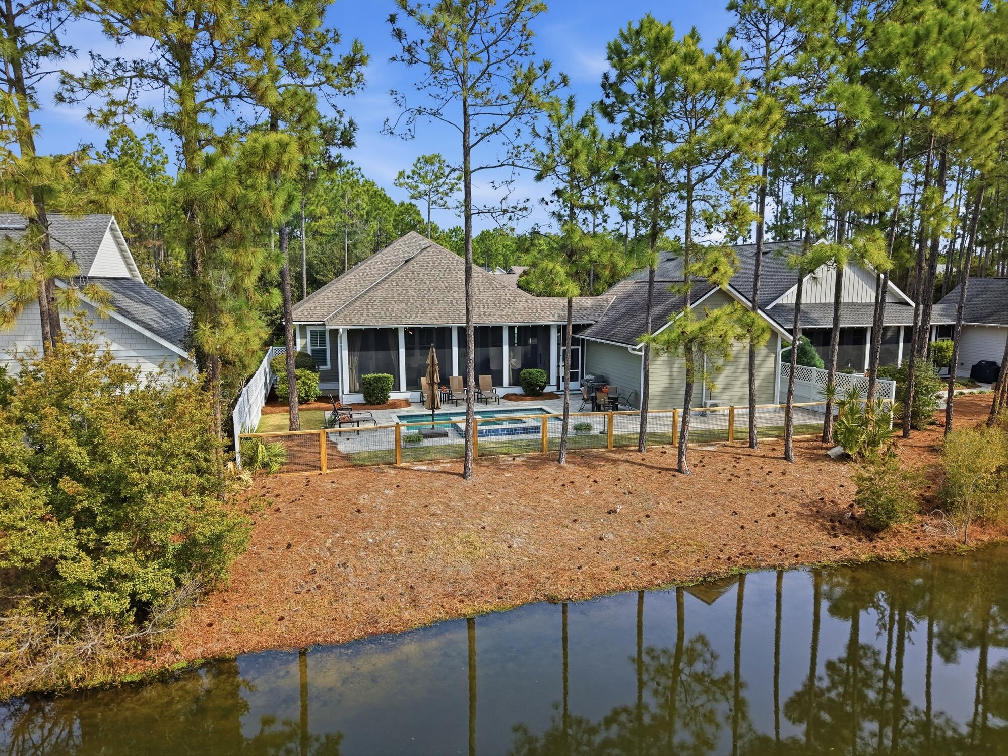 This single-level home offers a highly livable floor plan and a peaceful setting overlooking a tranquil pond and protected natural preserve that will remain undeveloped, providing lasting privacy and beautiful views.

Designed for exceptional indoor-outdoor living, the home features a screened porch with a fireplace that opens to a heated saltwater pool and hot tub--perfect for relaxing or entertaining year-round. With four bedrooms and a thoughtfully designed layout, the home is well suited for full-time living while also providing plenty of space for hosting visiting friends and family.

Situated on a street with community walking trails that wind through native plants and natural foliage, the setting creates a true connection to the surrounding landscape. Located minutes to 30A and 98. The home features exceptional indoor-outdoor living, including a screened porch with fireplace that opens to a heated saltwater pool and hot tub--perfect for relaxing or entertaining year-round. With four bedrooms and a thoughtfully designed layout, the home is well suited for a full-time family residence or for hosting visiting family and friends.The home has numerous builder upgrades designed to enhance both comfort and functionality. 10-foot ceilings create an open, airy feel, complemented by custom wainscoting, crown molding, and detailed trim work throughout the main living spaces. Built-in bookshelves anchor the den and living area, while a hallway bar features a wine cooler with custom cabinetry--ideal for entertaining.

Indoor living flows seamlessly outdoors to a private backyard retreat featuring a pool and spa, outdoor fireplace, and upgraded paver walkway extending from the driveway to the pool. The garage is fully air-conditioned, adding versatility and year-round usability.

Additional original builder enhancements include custom cabinetry and a laundry room closet, ceiling fans in all bedrooms, the den, and porch, wiring for a sound system in the den and back porch, and custom shutters throughout the home and garage. In the primary bath, battery-operated shutters allow for effortless light and privacy control.

The home has been meticulously maintained, with recent updates including a full exterior repaint in July 2024, refreshed white fencing along both sides of the pool, replacement of the rear pool fence, a new dishwasher installed in September 2025, and a new HVAC system completed in December 2025.

Since the home was photographed and the video was filmed, we have upgraded all of the recessed lighting to new fixtures with adjustable brightness and color settings.  We have also re-shot some of the photos not the video.