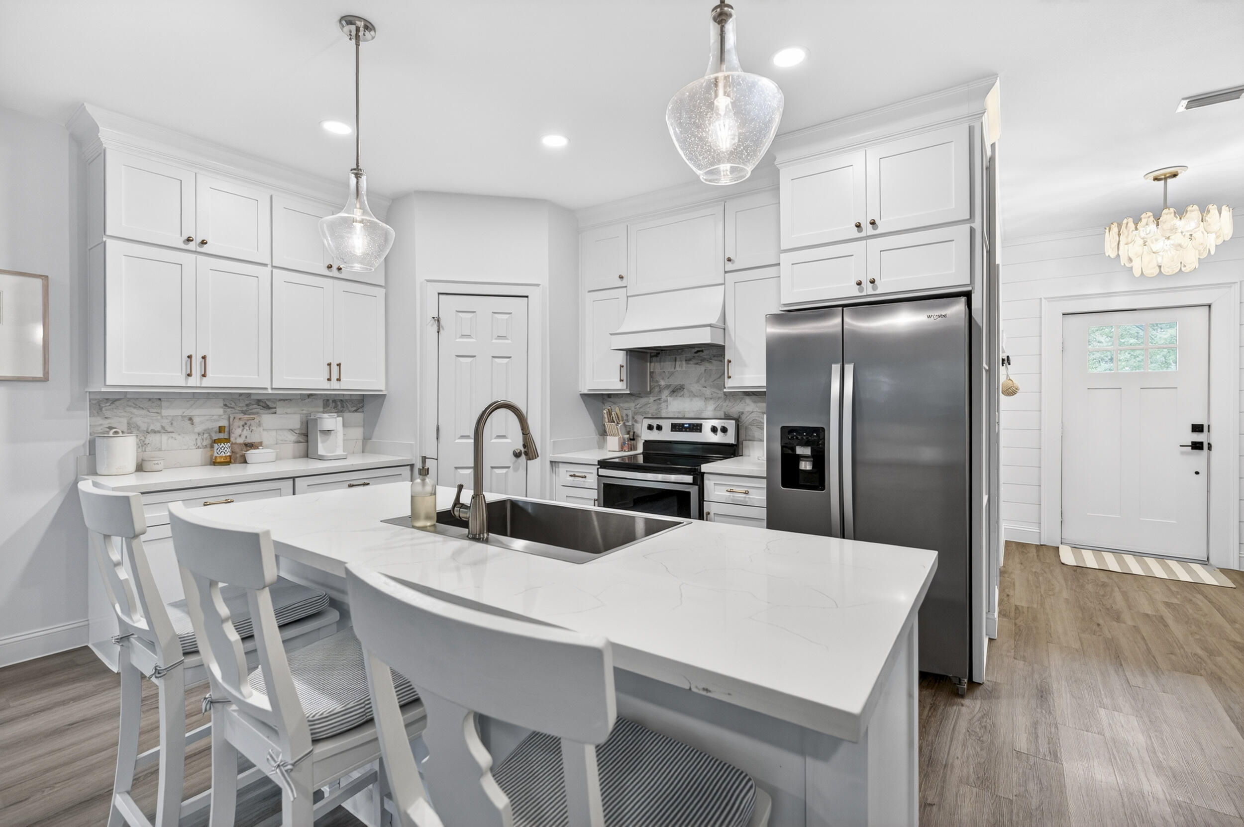 Bright, airy, and thoughtfully designed, this newer construction coastal-inspired 3BR/2BA home in Santa Rosa Beach offers an inviting open layout with $70K in upgrades and custom finishes. Shiplap accents, nine-foot ceilings, and luxury vinyl plank flooring create a light and relaxed feel, while the custom floor-to-ceiling built-in bookcase with electric fireplace adds warmth and character to the living space. The kitchen features quartz countertops, marble backsplash, oversized island, vent hood, and custom cabinetry extended to the ceiling. Additional highlights include a one-car garage, new exterior paint (2024), and no HOA or rental restrictions, offering added flexibility for full-time living, a second home, or investment potential. Conveniently located near Cessna Landing and just 10 minutes from 30A and Ed Walline Beach Access.