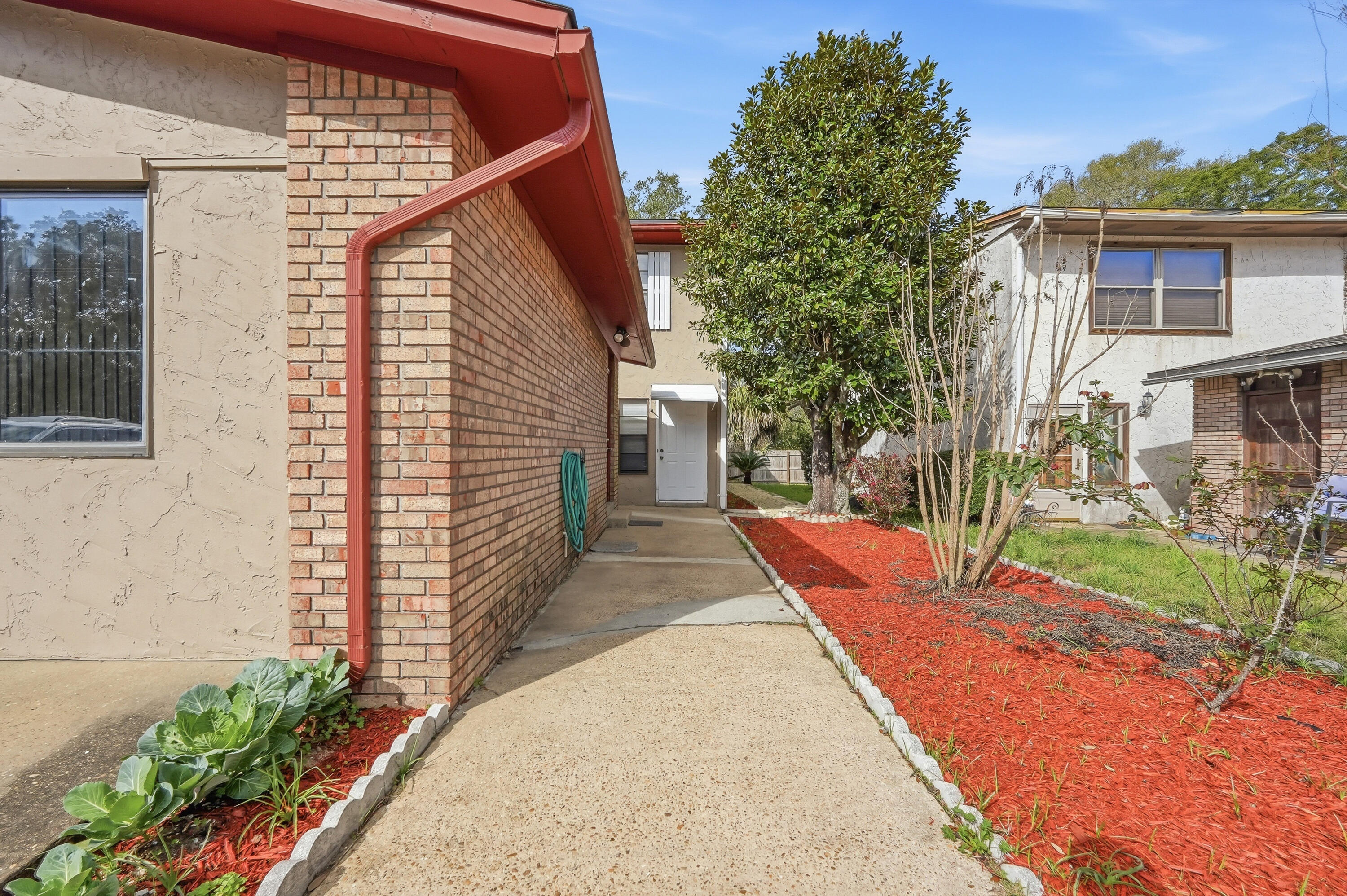 Great investment opportunity! The converted garage studio includes a private bath and kitchenette, perfect for guests, rental income, or multigenerational living. The main home features an updated kitchen with granite countertops, tile backsplash, two pantries, and stainless steel appliances.  Downstairs flooring is tile with vinyl flooring in the upstairs bedrooms. The spacious primary suite includes a private bath, and a Florida room off one guest bedroom adds extra living space. Beautiful landscaping surrounds a large covered patio and a brick-paver patio, ideal for outdoor entertaining. The main home offers 3 bedrooms and 3 bathrooms, while the separate studio adds an additional bedroom and bathroom, bringing the total to 4 bedrooms and 4 bathrooms. Roof 2020, HVAC 2016.