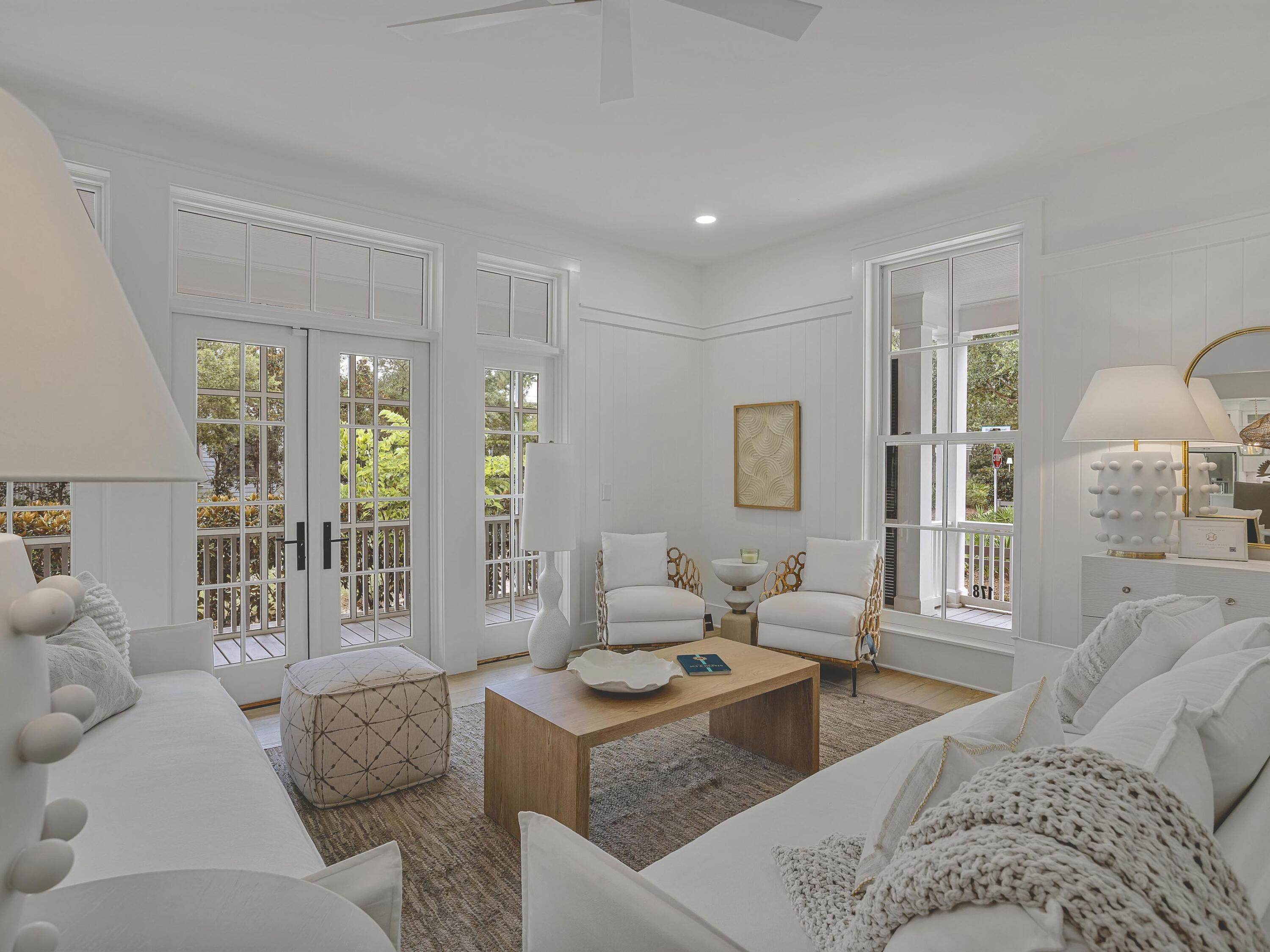 Completely and thoughtfully renovated, this exceptional five-bedroom, five-bath residence in Phase Three of WaterColor blends timeless coastal architecture with refined, modern updates. Enhanced beyond its original footprint, the home offers improved livability, beautifully refreshed interiors, and elevated finishes just steps from the Frog Pond Pool and park.

Positioned on a desirable corner lot, the property features over 1000 square feet of screened porches, creating seamless indoor-outdoor living. A charming paved path leads to the welcoming front porch, an ideal setting for relaxed mornings and sunset conversations. Inside, the light-filled sitting room flows effortlessly into an elegant dining space complete with a wet bar, buffet, and built-in wine cooler. Walls of windows and French doors illuminate the hardwood flooring and highlight the home's airy, open-concept design perfectly suited for entertaining and multi-generational gatherings.

The fully renovated kitchen is both sophisticated and functional, appointed with crisp white cabinetry, quartz countertops, stainless steel appliances, generous storage, and an oversized island with bar seating. A nearby side porch provides an intimate setting for alfresco dining.

The first-floor primary suite offers comfort and convenience with a spacious, spa-inspired bath featuring dual vanities and a soaking tub. Upstairs, beneath vaulted rooflines, you'll find a charming bunk room and two well-appointed ensuite bedrooms. A second-floor screened porch overlooks the peaceful, tree-lined streetscape, an inviting retreat for coffee or a quiet read.

A separate staircase leads to the private carriage house above the two-car garage, offering a spacious guest suite with room for a king bed and twin bunks, a sleek full bath, and a cozy sitting area ideal for guests or continued rental flexibility.

Complete with an attached garage and ample parking in the paved courtyard, residents enjoy access to miles of scenic trails and boardwalks, pocket parks, resort-style pools, and the coveted amenities that define the WaterColor lifestyle.