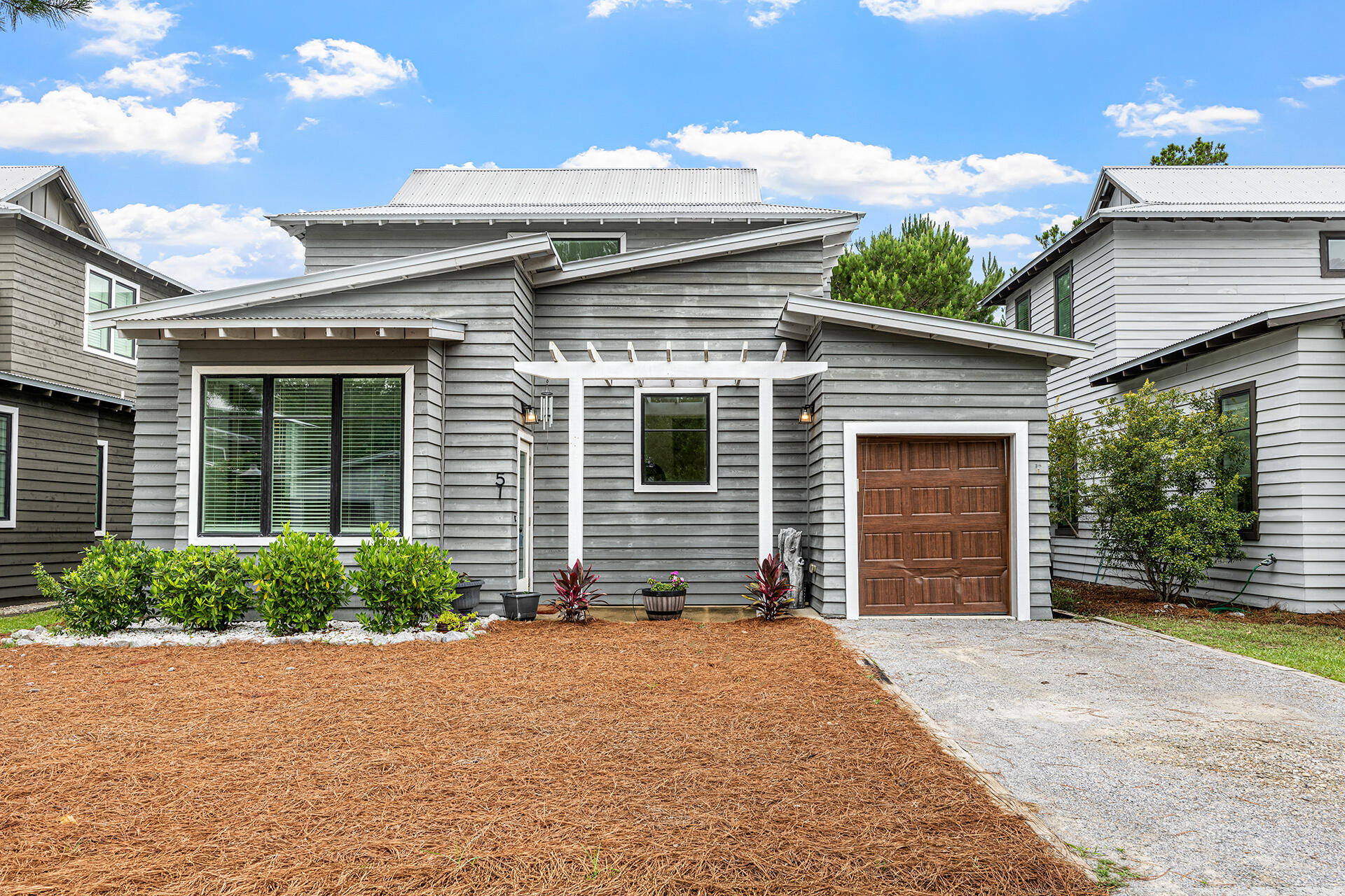 Get ready to fall in love with a home that's pure coastal-cool with a modern, high-energy twist! Located right by the lush greenery of Eden Gardens State Park, 51 Edens Landing Cir is where laid-back living meets high-end style. From the striking cedar wood siding to that charming pergola, this place has 'wow factor' written all over it.
Step inside and feel the vibe--it's airy, open, and flooded with light. The tall ceilings and warm wood floors create a space that's expansive yet perfectly cozy. If the kitchen is the heart of the home, this one is beating fast! We're talking a fully-equipped culinary playground featuring sleek stainless appliances, crisp quartz countertops, and a breakfast bar that's practically begging for morning lattes and good conversation. The main level serves up a primary suite that feels like a total getaway, complete with a spa-inspired ensuite and a walk-in closet ready for your boutique finds. Head upstairs to find two more bright bedrooms and a second full bath, giving everyone plenty of space to recharge. And because we know life is busy, the dedicated laundry room keeps everything organized and effortless. Living in the non-rental community of Eden's Landing means you've got access to a sparkling pool and the nearby Point Washington boat launch for when the water calls your name. When you're craving a little action, the boutiques and energy of Seaside and Watercolor are just a quick trip away.