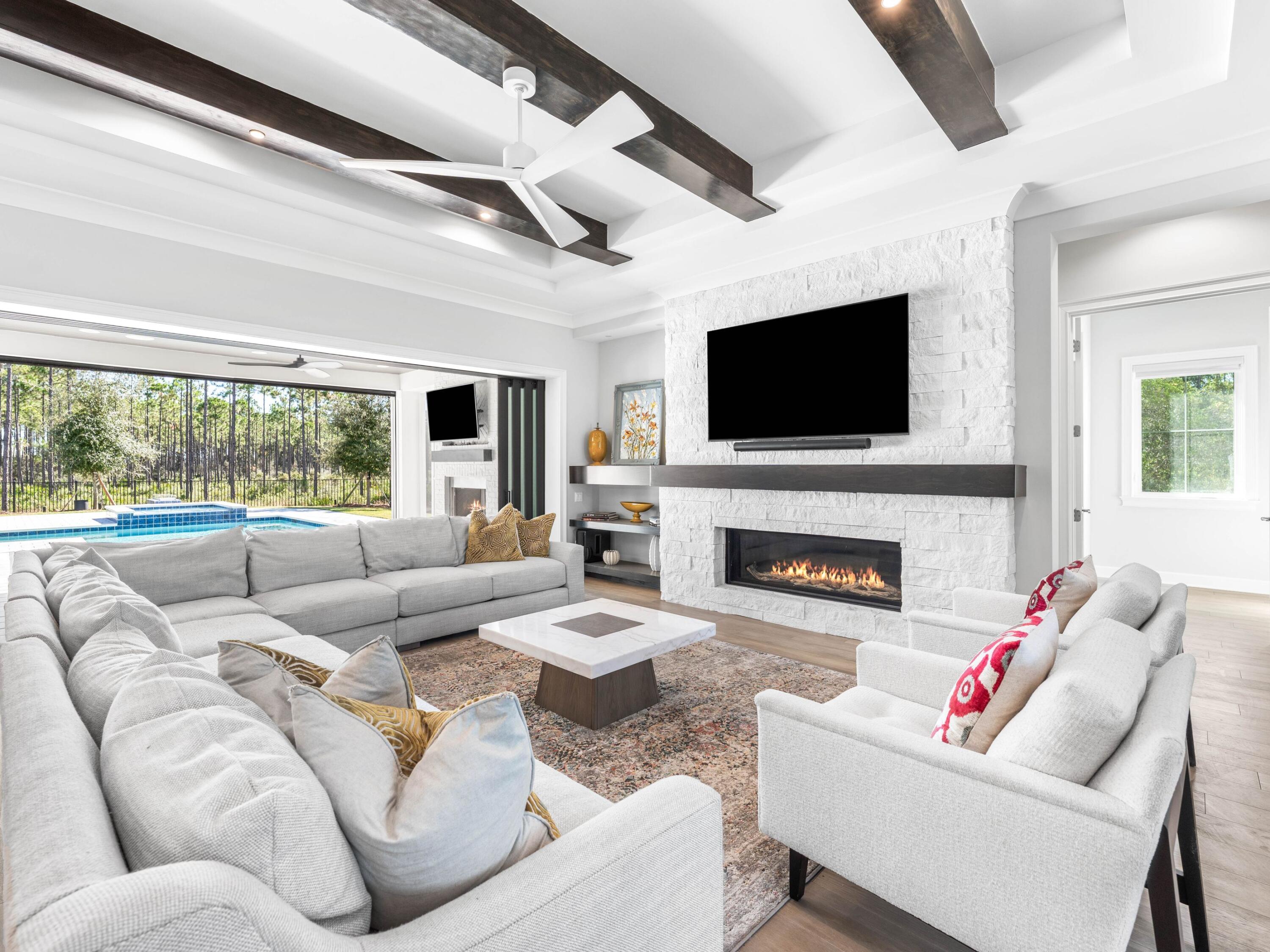This magnificent residence is situated on .43 acres in the coveted community of Watersound Camp Creek which is a much larger homesite than most of the neighborhood. 172 Norman Court pairs 5,501 square feet of thoughtfully designed living space with finishes and features that are difficult to match for under $5 million. To help visualize furniture placement many of the photos have been digitally staged. The main level is built around a central open-concept living area with hardwood floors, custom built-ins, and a linear gas fireplace. NanaWall sliding doors erase the boundary between the indoor living space and the outdoor kitchen and porches, creating a single entertaining footprint that flows from the kitchen island to the pool terrace without interruption. The kitchen features commercial-grade stainless appliances with a six-burner range and skillet, custom cabinetry,

and a large center island. A hidden scullery includes an additional refrigerator, dishwasher, sink, and deep pantry storage which keeps the main kitchen in pristine condition while entertaining. A 200-plus bottle climate-controlled wine room and a dedicated wine cooler in the dining area are included.
The primary suite is on the main level. It features a tray ceiling, a generously scaled ensuite with raised ceilings, designer tile, soaking tub, oversized shower, an expansive walk-in closet, and a dedicated safe room. A first-floor guest bedroom with ensuite bath, full laundry room, and a sand room with built-in storage complete the ground level. An integrated Sonos sound system runs throughout the home.
The outdoor living area is designed for year-round use. Retractable motorized screens enclose a covered space with summer kitchen, gas fireplace, and seating for large groups. The spacious backyard opens up to the heated pool and spa enclosed by a permanent wooded buffer so no future construction or neighbors.

The second floor offers an expansive secondary living area with wet bar that is large enough to function as a game room, home theater, or golf simulator space. Three additional bedrooms, each with its own full ensuite bath, complete the upper level. Every bedroom in this home has its own ensuite bath. Other notable features of this all brick residence include the attached 3-car garage and dedicated office.
Ownership conveys exclusive Watersound Club membership -- three golf courses including the Tom Fazio-designed Camp Creek course and the new Davis Love III-designed The Third course, gulf-front Beach Club with complimentary chair and umbrella service, 11,000-square-foot wellness center, resort pools, tennis and pickleball courts, and multiple private dining venues. Fewer than 15 developer homesites remain in the community.