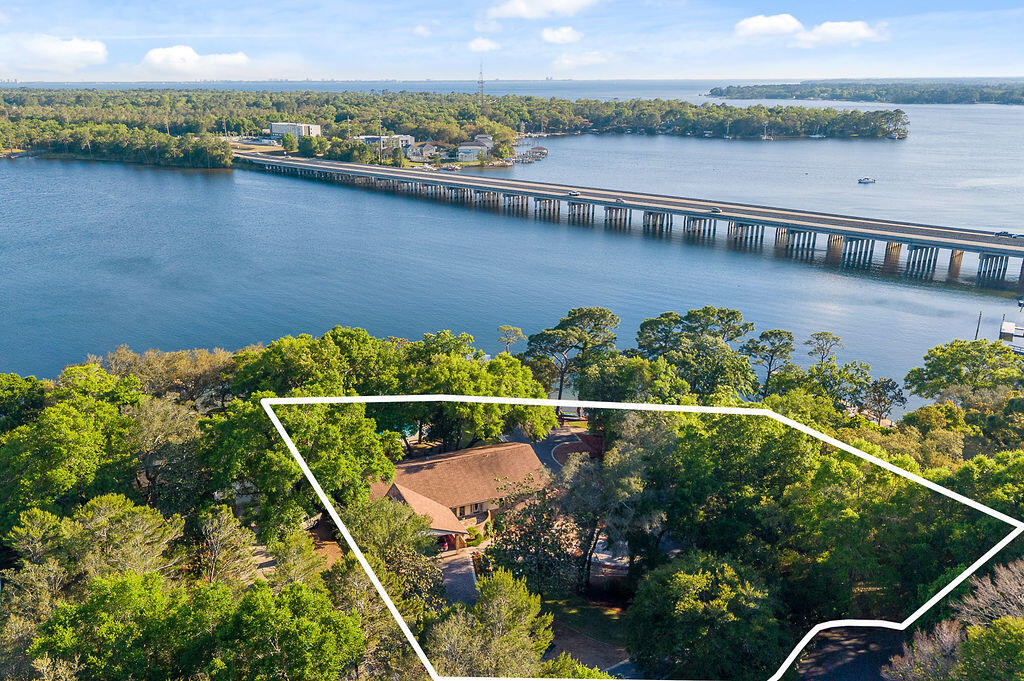 Own a piece of paradise! This is the waterfront lifestyle so many dream about, truly a rare opportunity on beautiful Rocky Bayou in Niceville with approx. 276+/- feet of bay frontage, your own private boat launch, 3 boat lifts, a sparkling pool, private pond, and dolphins frequently swimming just beyond the backyard. Situated on two parcels (Parcel ID's 10-1S-22-2834-0000-0050 & 10-1S-22-2834-0000-0040), this one-of-a-kind property offers an incredible combination of waterfront living, boating convenience, and peaceful outdoor space. Home features 4 bedrooms and 4 full baths, with every bedroom offering its own en-suite bath for comfort and privacy. Inside, the spacious great room showcases a dramatic cathedral ceiling and a cozy wood-burning fireplace, creating an inviting centerpiece for gatherings and everyday living. The kitchen offers custom built-ins, well-maintained cabinetry, a breakfast nook overlooking the property, and an oversized dining room perfect for entertaining. Step outside and experience what makes this property truly exceptional -- expansive waterfront views, multiple outdoor living spaces, a beautifully updated pool, private dock access, and room to enjoy boating, fishing, paddle boarding, kayaking, or simply relaxing by the water.
Recent improvements include:
• Pool resurfaced/redone in 2025
• Dock redone in 2025 with protective plastic wrap around poles
• All 3 HVAC systems replaced in 2025
• Roof replaced in 2018
• Brand new Workshop built in 2025 For your peace of mind the home has a whole house generator. 
Enoy your own private boat launch. 2 boat lifts, one 6000Lbs, one 25,000lbs.  Double sea do lifts 4000lbs. Wrap around porches. Walk out basement to give you the best out door space.  
Whether you are searching for a primary residence, second home, or a true waterfront retreat, this Rocky Bayou property offers an extraordinary setting that is difficult to replicate.
