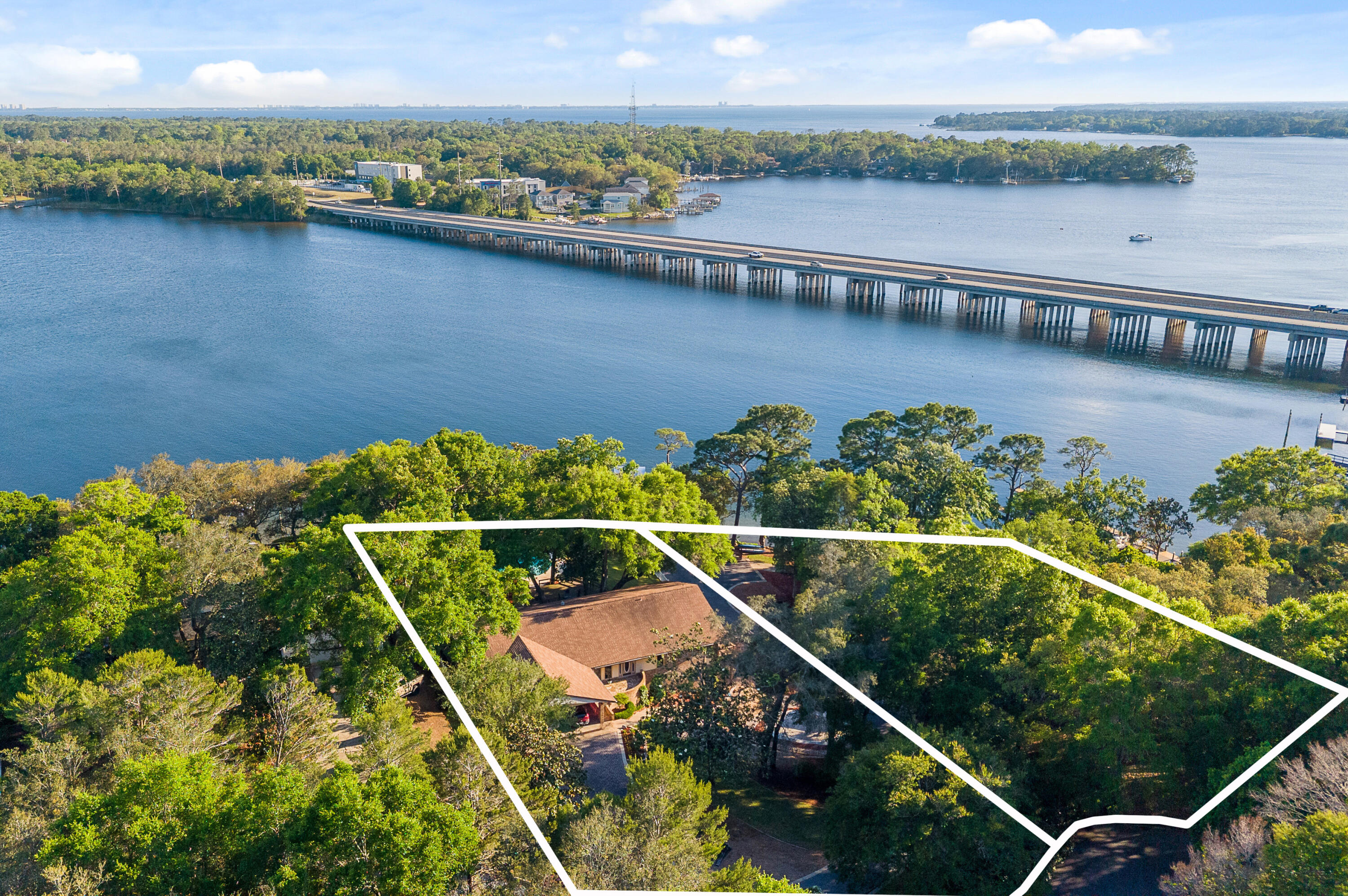 Own a piece of paradise! This is the waterfront lifestyle so many dream about, truly a rare opportunity on beautiful Rocky Bayou in Niceville with approx. 276+/- feet of bay frontage, your own private boat launch, 3 boat lifts, a sparkling pool, private pond, and dolphins frequently swimming just beyond the backyard. Situated on two parcels (Parcel ID's 10-1S-22-2834-0000-0050 & 10-1S-22-2834-0000-0040), this one-of-a-kind property offers an incredible combination of waterfront living, boating convenience, and peaceful outdoor space. Home features 4 bedrooms and 4 full baths, with every bedroom offering its own en-suite bath for comfort and privacy. Inside, the spacious great room showcases a dramatic cathedral ceiling and a cozy wood-burning fireplace, creating an inviting centerpiece for gatherings and everyday living. The kitchen offers custom built-ins, well-maintained cabinetry, a breakfast nook overlooking the property, and an oversized dining room perfect for entertaining. Step outside and experience what makes this property truly exceptional -- expansive waterfront views, multiple outdoor living spaces, a beautifully updated pool, private dock access, and room to enjoy boating, fishing, paddle boarding, kayaking, or simply relaxing by the water.
Recent improvements include:
• Pool resurfaced/redone in 2025
• Dock redone in 2025 with protective plastic wrap around poles
• All 3 HVAC systems replaced in 2025
• Roof replaced in 2018
• Brand new Workshop built in 2025 For your peace of mind the home has a whole house generator. 
Enoy your own private boat launch. 2 boat lifts, one 6000Lbs, one 25,000lbs.  Double sea do lifts 4000lbs. Wrap around porches. Walk out basement to give you the best out door space.  
Whether you are searching for a primary residence, second home, or a true waterfront retreat, this Rocky Bayou property offers an extraordinary setting that is difficult to replicate.