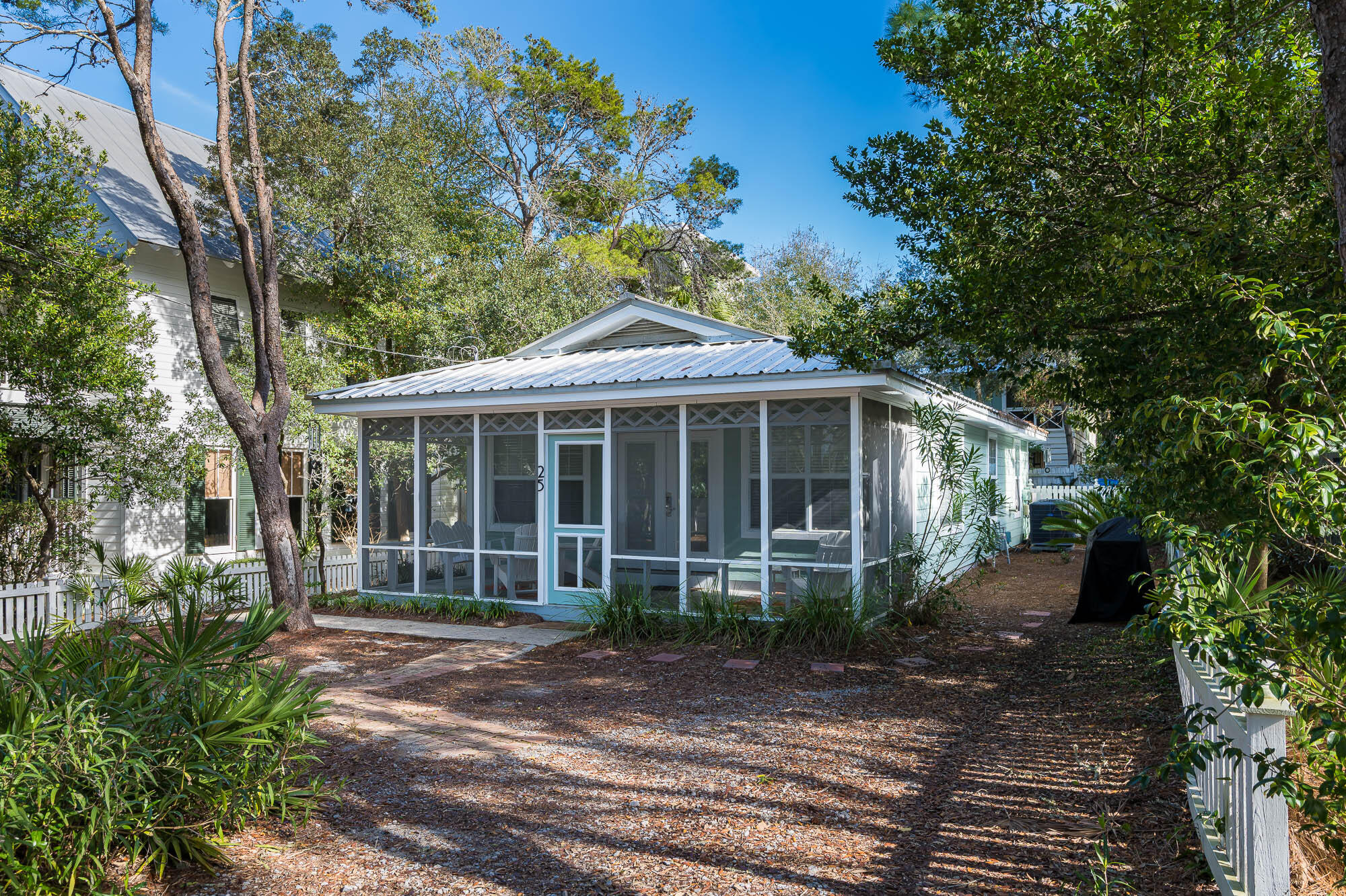 One block from Seaside!  Tucked away in the heart of Old Seagrove, this charming beach cottage offers the perfect blend of coastal character and relaxed living. A picturesque white picket fence welcomes you in, setting the tone for the warmth and charm that carries throughout the home. The screened-in front porch is ideal for slow mornings with coffee or unwinding after a day in the sun.
Inside, the open-concept living space is bright and inviting, with hardwood floors flowing seamlessly throughout. The galley-style kitchen is both functional and efficient, opening into the main living and dining areas to keep everything feeling connected and easy.
With three bedrooms and two full baths, there's plenty of space for family or guests. One of the bedrooms features direct access to the pool deck, creating a private retreat with effortless indoor-outdoor flow. Step outside to your own backyard oasis, complete with a private pool and outdoor shower, perfect for rinsing off after the beach, which is just a quick four-minute walk away. 

For dining, shopping, and entertainment, Seaside town square is less than half a mile down the road. Surfing Deer is right around the corner. Being in the heart of Old Seagrove, you have easy access to both casual and fine dining, shopping, and entertainment, all within 1 mile.