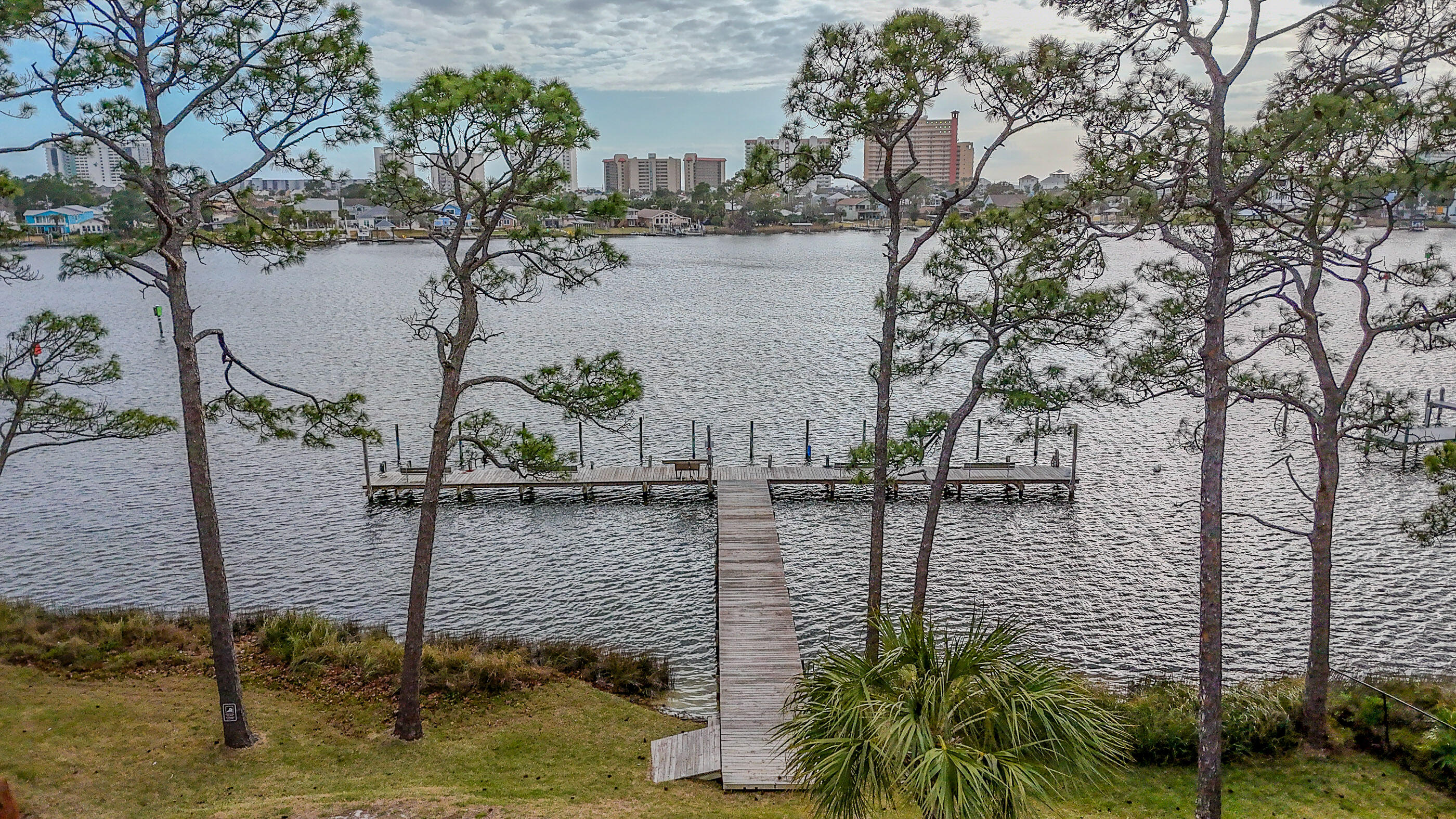 Waterfront living at Grand Lagoon Cove! This 2BR/2BA lagoon-front condo offers direct water views, dock access, and a rare opportunity to own in one of North Lagoon's true waterfront communities. Enjoy peaceful mornings from your covered balcony overlooking the lagoon and green space. Community amenities include a pool, tennis courts, and shared dock access (slip use subject to HOA rules and availability). Recent updates include LVP flooring, stainless appliances, water heater replaced October 2025, and HVAC replaced in 2013. Short-term rentals are permitted per association guidelines. Conveniently located near beaches, marinas, dining, and St. Andrews State Park. Grand Lagoon Cove is a true lagoon-front community offering direct water access along highly desirable North Lagoon Drive. The community features a pool, tennis courts, and shared dock facilities designed for enjoying the boating lifestyle. There are approximately 10 boat slips serving 54 units, and slip assignments are managed by the association on a first-come basis subject to availability and HOA rules. Slips are generally intended for resident owners, and renters are not eligible to obtain slip assignments. Buyers should verify current availability, any waiting list, and applicable fees directly with the association. Inside, the unit offers a functional two-bedroom, two-bath layout with lagoon views from the covered balcony, making it suitable as a primary residence, second home, or investment property. Located just minutes from Gulf beaches, public boat ramps, marinas, shopping, and restaurants, this property provides convenient access to everything Panama City Beach has to offer while maintaining a quieter waterfront setting. All ages, measurements, square footage, rental guidelines, boat slip availability, and room sizes are approximate; buyer to verify all information deemed important.