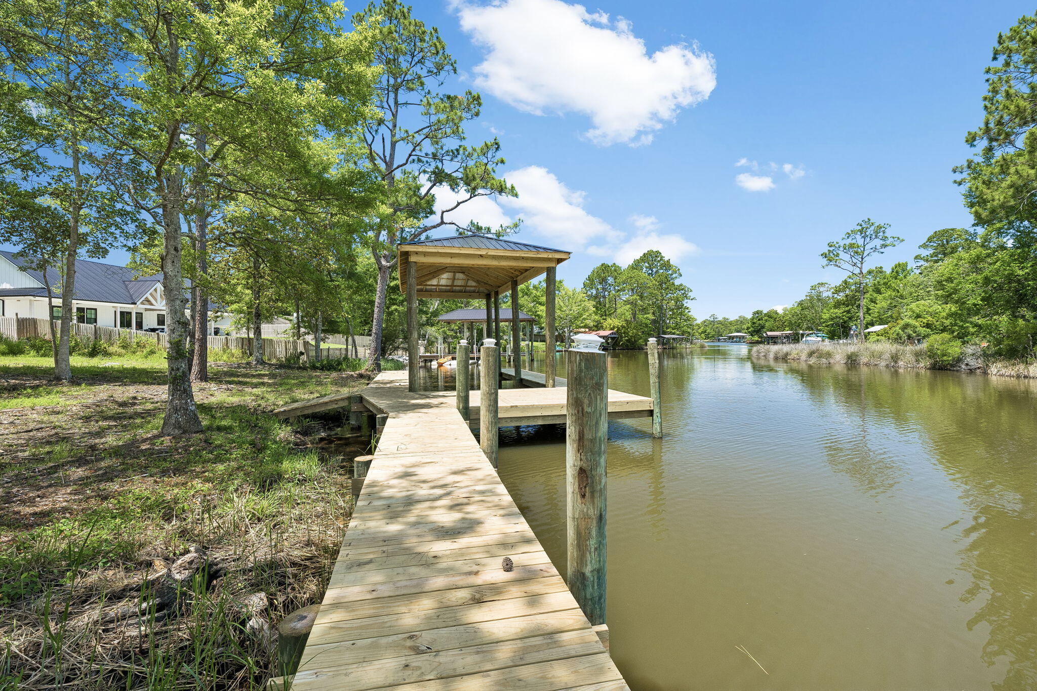 Discover the perfect canvas for your coastal dream home on this exceptional canal front lot just outside the Freeport city limits. Ideally positioned only 10 minutes from the world renowned Beaches of South Walton, this rare offering combines peaceful waterfront living with unbeatable convenience. Spanning just over a half acre, the property provides direct access to Mallet Bayou and seamlessly connects to the Choctawhatchee Bay, offering endless opportunities for boating, fishing, and exploring the gulf waters beyond the bay. A new boathouse with additional dock space are already in place, providing immediate functionality and added value for water enthusiasts. This canal runs 4-5' in the center. The Choctawhatchee Bay, a stunning 30 mile estuary stretching across Okaloosa and Walton counties, is fed by the Choctawhatchee River and opens to the Gulf of Mexico through the Destin East Pass, making this location a true gateway to some of the Panhandle's most sought-after waterways. Whether you're envisioning a private waterfront retreat or a full time residence, this property delivers the ideal balance of seclusion and accessibility, tucked away in a serene setting while still just minutes from shopping, dining, schools, and the sugar-white sands of the Emerald Coast.