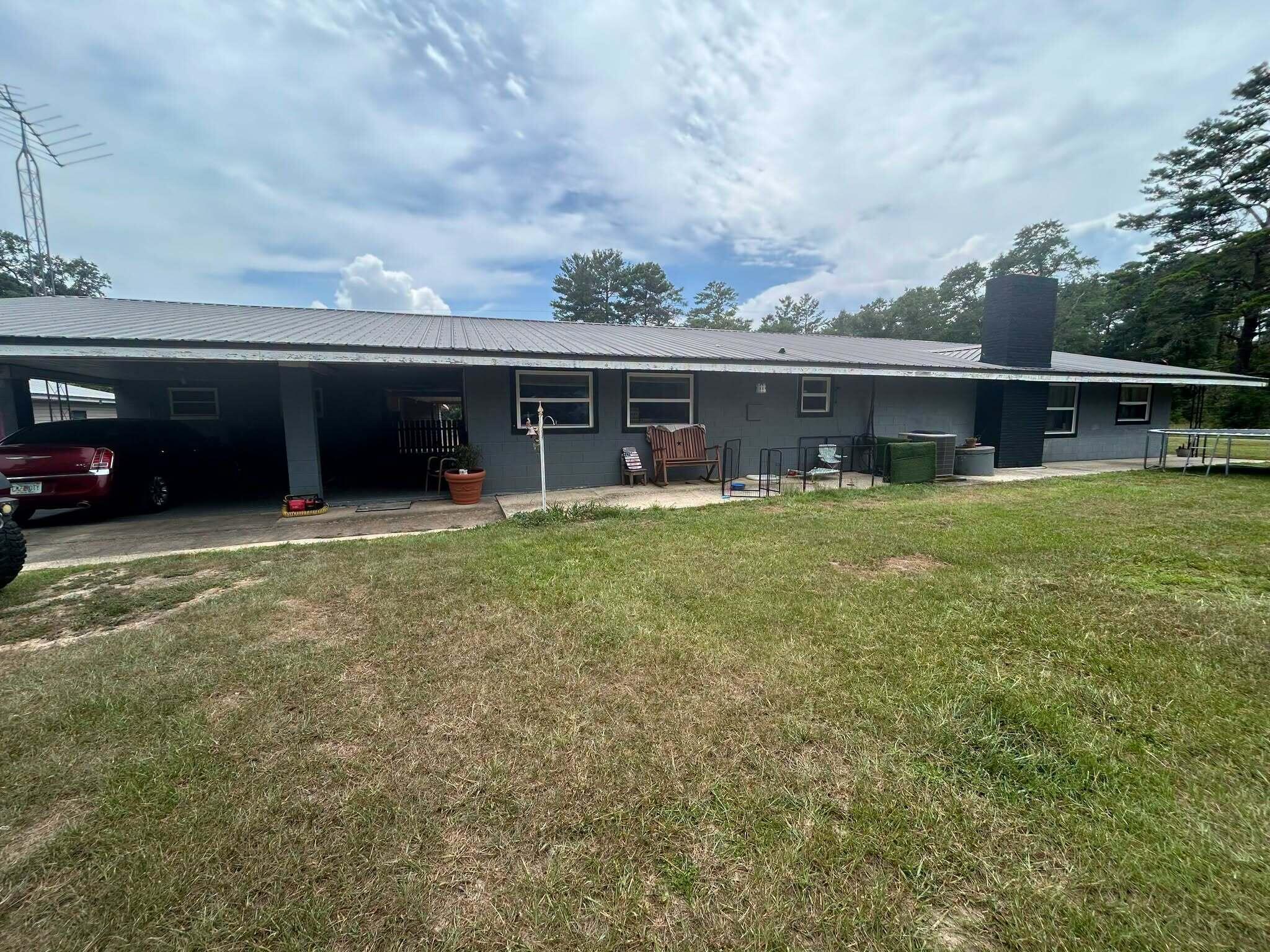 PRICED to SELL! Finding a home with mini farm in rural Red Bay is rare. Check out this large home on nearly 2.5 acres that is solid built with block construction, metal roof, and plaster walls. 3275 square feet with 4 bedrooms and 3 full baths! There is also au finished separate 800 sq ft apartment or Mother-in-law space with a large living area, bedroom, it's own carport, and a kitchenette! Has been an income producer on AirBNB Bring your animals because there is fenced pasture and pens for small livestock. If you enjoy swimming, the above-ground pool is READY for that dip, jump in off the renovated deck.  Enjoy the quiet and peaceful enjoyment of country life, convenient to I-10 and just 30 minutes to the beautiful sugar white sand beaches of Panama City Beach and Santa Rosa Beach.