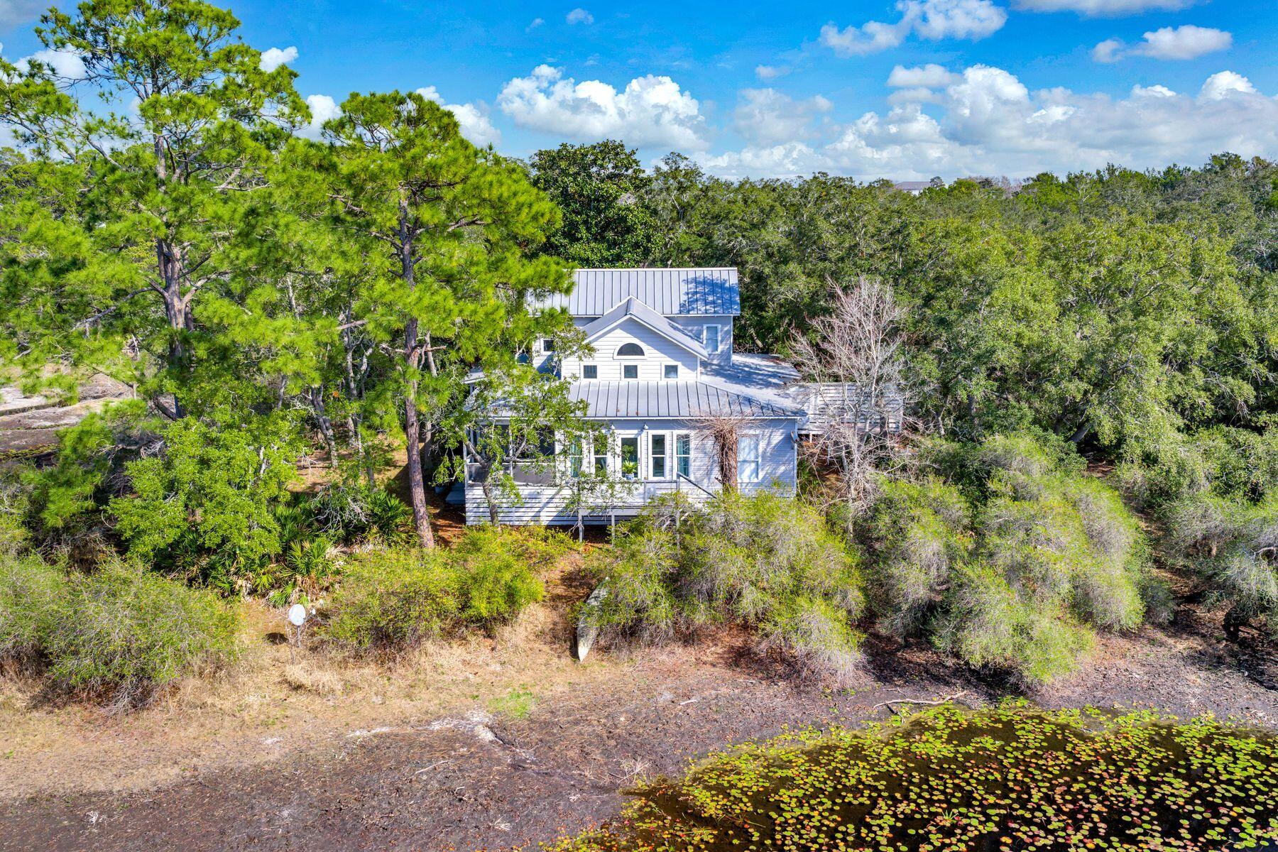A rare six-acre private family compound in Blue Mountain Beach tucked away from the noise of the world, yet uniquely positioned only three blocks from the Gulf of Mexico and beach access, this extraordinary sanctuary is a living, breathing landscape. The compound boasts apprx 2.5 upland acres zoned NP Infill which allows up to eight structures per acre. The classic coastal cottage rests at the water's edge with a lake view from every room.  At its heart lies a three-acre spring-fed lake, its water so clear and still on quiet mornings that the ancient live oaks surrounding it see their own reflection. And those oaks draped in Spanish moss with cathedral arms are magnificent. Sitting beneath them is a charming 2200 sf coastal cottage that has been showcased in various magazines with views of the lake from every room. The property also boasts an artist's studio, two story of approx 750 sf, and a woodworking shop or toolshed.  Local restaurants, seafood store, pubs, ice cream shop and boutiques are all within an easy stroll.  The Gulfview Heights beach access is walkable and state forest hiking trails are easily accessible at the north end of the street.