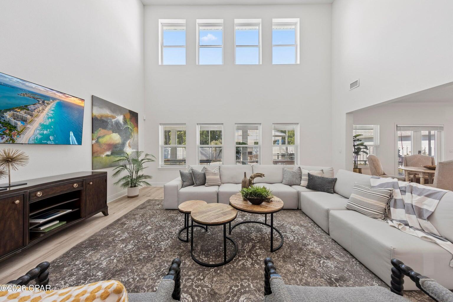 Some homes are listed--this one makes a statement. Fully upgraded and designed for entertaining on a rare half-acre corner lot. The sought-after Elliot floor plan features a first-floor primary suite for comfort and privacy. A chef-inspired kitchen with quartz countertops, a large island, and an open flow anchors the home. Enjoy not one but two spacious living areas for relaxing or hosting. Upgrades include luxury vinyl flooring, modern finishes, and a custom wine and beverage station with built-in storage and fridge. Step outside to screened porches, paver upgrades, an outdoor kitchen with a premium grill, and a pavilion with seating and a fireplace. Spacious, private, and close to beaches, dining, and shopping--this is coastal living elevated.