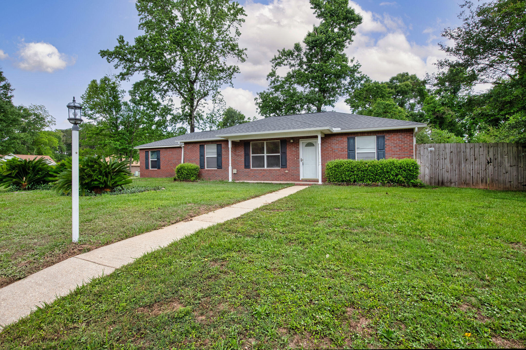 This brick home sits on a 0.5 acre corner lot with a fenced yard for privacy. As you enter the home, you are step into the spacious living room which flows into the dining area. The galley kitchen has new granite counter tops. The primary bedroom is off the living room with a full bath connecting to the laundry room. On the opposite side of the home are 2 additional bedrooms and a full bath. Both bathrooms have new granite counters. Laminate floors and a fresh coat of paint make this home even more welcoming. Double doors from the dining area open up to the fenced back yard with room for a pool. NO HOA.  Schedule your visit today
