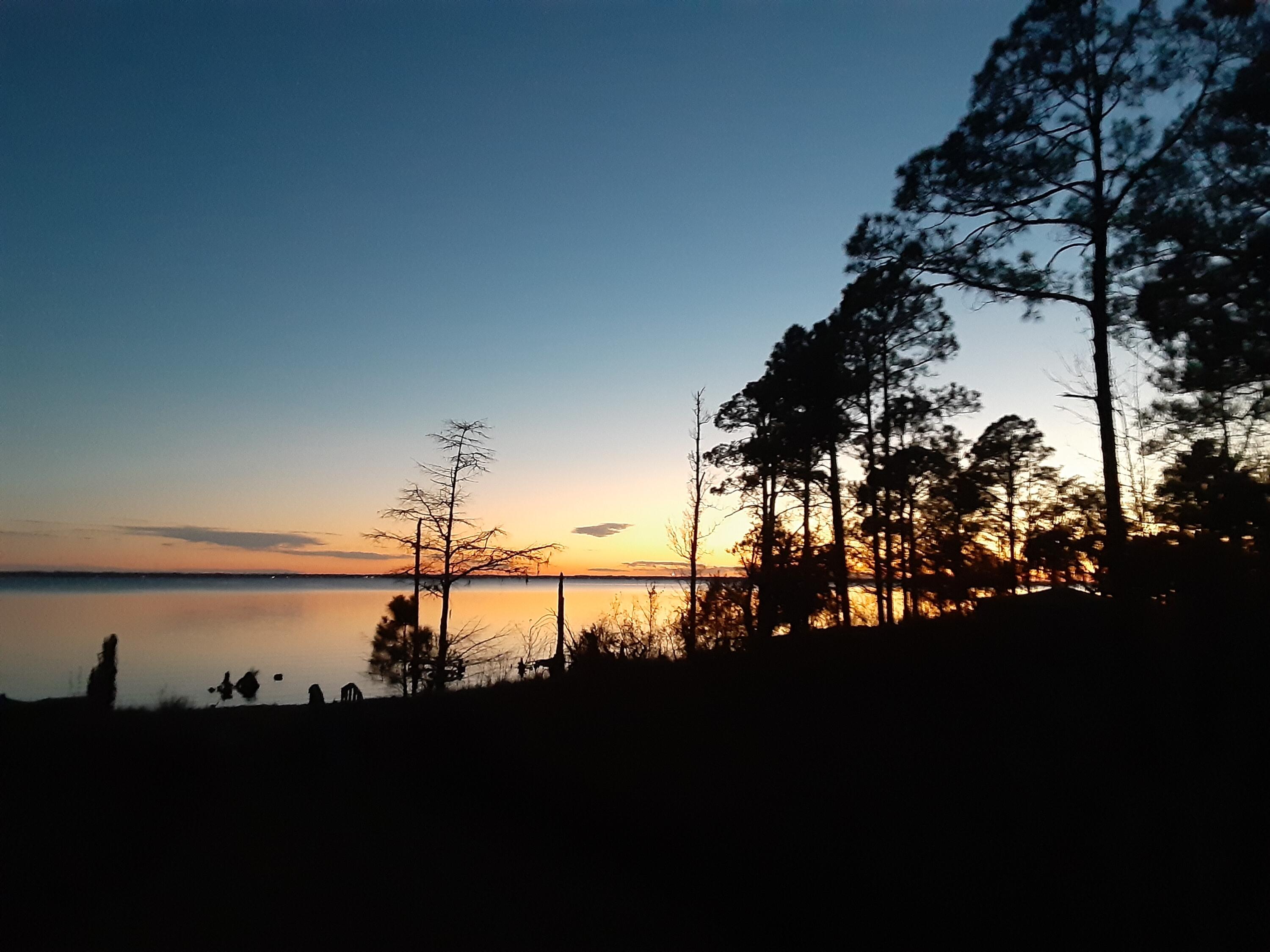 Tucked away on Choctawhatchee Bay, this charming Florida cottage is a true private waterfront escape. With protected wetlands on one side and a wooded buffer on the other, your views and peaceful setting feel wonderfully secluded. Inside you'll find 1 bedroom (plus a flexible bonus sleeping space for guests). The star of the show? A 15' x 28' covered bayfront porch—the perfect spot for morning coffee, sunset dinners, and salty breezes. From your own shoreline, enjoy fishing, and watch bald eagles, dolphins, and marine life glide by. A special bayfront opportunity to enjoy now—while you plan your future dream home.