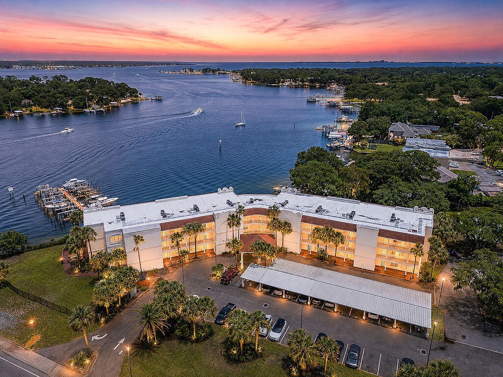 Welcome to waterfront living at Laguna Landing Condominiums, a hidden gem tucked along the Cinco bayou in the heart of Fort Walton Beach. Located in a boutique waterfront community, this beautifully updated 2 bed, 2 bath condo offers breathtaking bayou views, spectacular sunrises and sunsets, and front-row seats to holiday fireworks right from your own private balcony. Perfectly positioned on the second floor, Unit #206 offers a rare blend of peaceful waterfront living w/close proximity to shopping, dining, both military bases, parks, downtown FWB, & the white sandy beaches of the Emerald Coast. Inside, this thoughtfully upgraded condo showcases over 1,200 sqft of light & bright living space with 20'' x 20'' tile flooring throughout & a fully reconfigured kitchen designed for both beauty & function. The kitchen renovation added 4 upper cabinets, 2 lower cabinets, and an additional drawer for expanded storage, relocated the refrigerator into the former pantry space for improved flow, & created a new pantry in the laundry room. Updated countertops, sink, cabinetry, & appliances complete this modern coastal space ideal for entertaining or everyday living. The spacious primary suite offers room to relax while enjoying water views and features custom room-darkening curtains. Both bathrooms have been beautifully updated with new countertops & cabinetry, adding additional drawer storage & functionality. Accessibility was thoughtfully considered throughout the unit w/handicap-width doors, creating ease of movement & long-term convenience. Additional upgrades include a new A/C compressor (May 2022), new water heater (March 2022), hurricane-rated window (February 2024), updated lighting & paint, Levolor blinds/curtains in the living space & front bedrm, & an audio/video doorbell system. Enjoy peaceful mornings watching boats pass by from your balcony & evenings taking in stunning sunsets over the bayou, or the daily dolphin sitings. Unit also has a partial view of the community pool & views of the holiday fireworks displays hosted by AJ's on the Bayou. An assigned covered parking space #1 conveys with the unit. The HOA fee includes exterior building insurance, water/sewer, cable/internet service, pool maintenance, lawn care, quarterly termite, bi-weekly janitorial service for common areas, & annual fire sprinkler testing, making for low-maintenance stress free waterfront living. Perfect for anyone dreaming of a move-in ready waterfront condo w/exceptional upgrades, accessibility features, & unbeatable bayou views, this is one you do not want to miss. Laguna is a long term residential complex w/no short-term rentals allowed giving the added bonus of peaceful bayou living on the Emerald Coast.