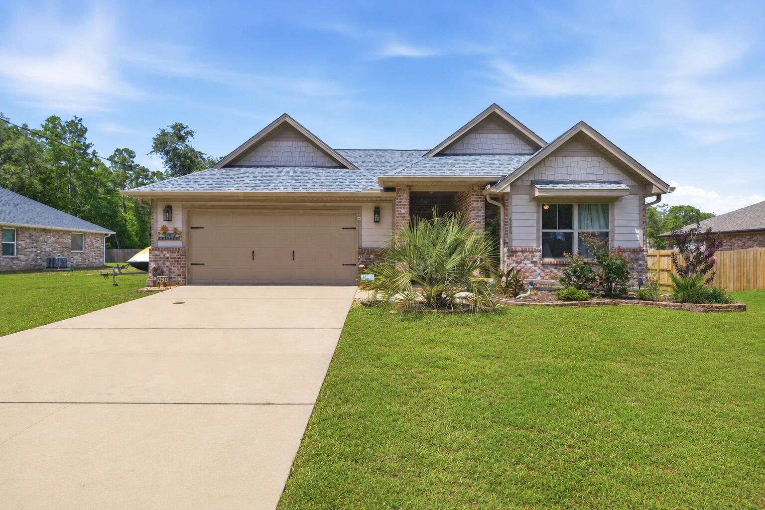 OPEN HOUSE! SATURDAY, 6/6 FROM 11AM-2PM. Peaceful country living with modern convenience! Located just off Garcon Point Road in desirable Flood Zone X, this beautifully maintained 2022 all-brick home sits on a spacious 0.30-acre lot with NO HOA, offering the perfect blend of privacy, comfort, and freedom. Featuring 3 bedrooms, 2 bathrooms, 2,044 square feet, and a 2-car garage, this home boasts a bright open floor plan with quality finishes throughout. The kitchen offers granite countertops, stainless steel appliances, solid wood soft-close cabinetry with dovetail drawers, oversized upper cabinets, and a range hood vented through the roof. Additional features include Low-E vinyl windows, recessed lighting, tile flooring in wet areas, and durable carpeting. The spacious primary suite includes a large walk-in closet, soaking tub, and separate shower. Outside, enjoy a covered front porch, screened-in back porch with ceiling fan, and upgraded Polyurea-coated patios. The backyard is pool-ready, with the septic system positioned to the side for maximum usable space. Additional upgrades include heavy-duty gutters, Nest thermostat, Arlo video doorbell, termite bond with Arrow Pest Control, extra electrical service for an RV, boat, or future generator hookup, and a storage shed that conveys. Perfectly located away from the hustle and bustle, yet only about 25 minutes from Pensacola, Navarre, and the area's beautiful white-sand beaches. This move-in ready home truly offers the best of Florida living!