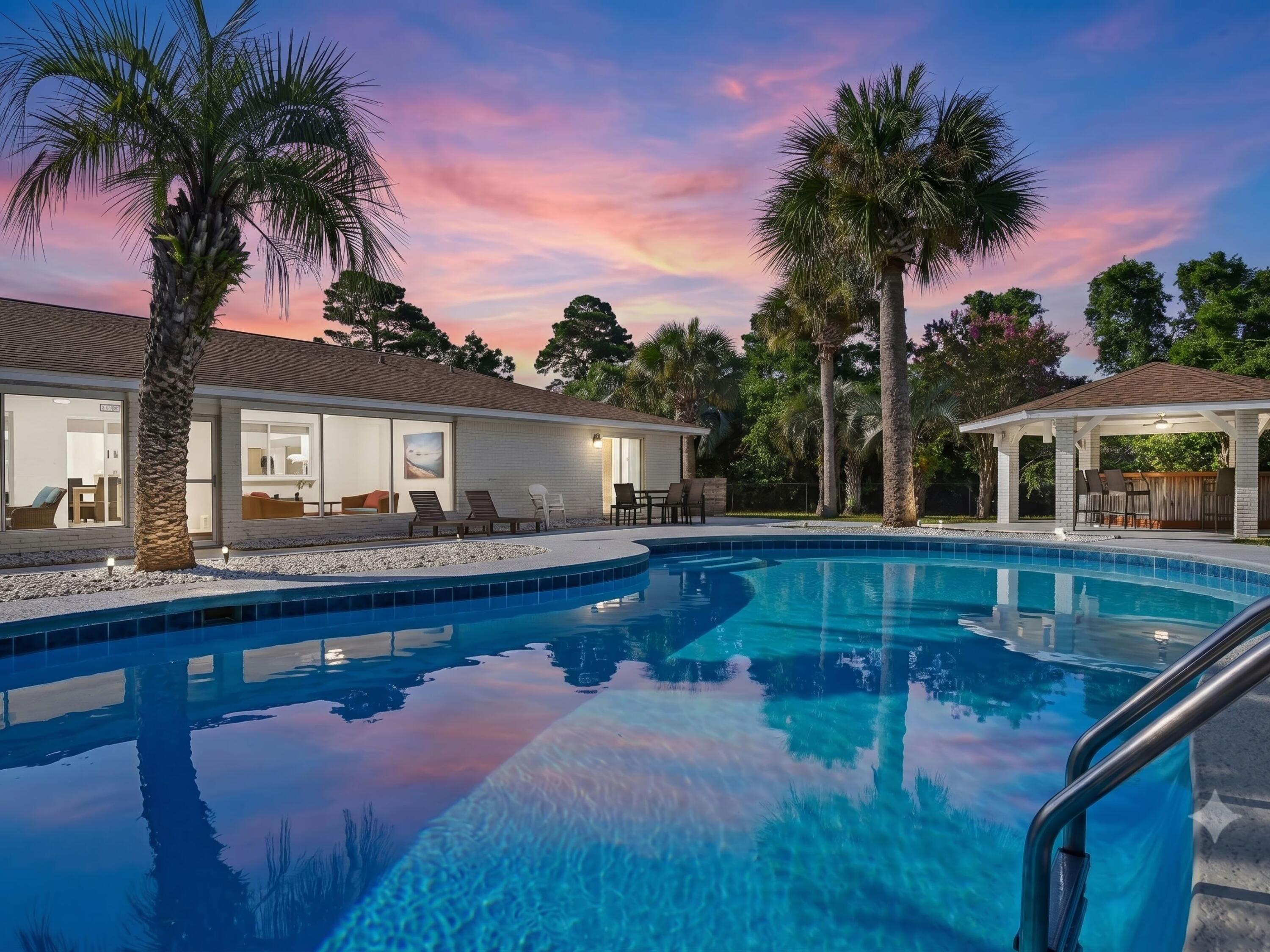 Set on an exceptionally rare three-quarter-acre homesite just a short stroll from the sugar-white sands of the gulf, this fully furnished six-bedroom coastal retreat offers the space, privacy and amenities that today's buyers and vacation renters are searching for. Located south of U.S. Highway 98 in the quiet beachside community of Gulf Pines, the home pairs an impressive outdoor setting with a thoughtfully designed single-level floor plan, creating an inviting destination for large families, entertaining and memorable beach getaways.

Inside, the open-concept living, dining and kitchen areas are designed to keep everyone connected. The gourmet kitchen is equipped with high-end stainless steel appliances and generous workspace, while multiple gathering areas make it easy to host holidays, reunions or relaxing weekends at the beach. Six spacious bedrooms and four beautifully updated bathrooms comfortably accommodate family and guests, including four king bedrooms, a bedroom with two queen beds and a dedicated bunk room with three twin bunk beds.

The outdoor living experience is truly the centerpiece of the property. Surrounded by mature tropical landscaping and approximately 87 swaying palm trees, the backyard feels like a private resort. A lagoon-style swimming pool anchors the space, complemented by a covered cabana, outdoor kitchen, pavilion bar with wraparound seating and a spacious screened porch that extends the living area outdoors. A fire pit creates the perfect setting for evenings under the stars, while ping pong, cornhole and multiple lounging areas encourage endless hours of entertainment for guests of every age.

Whether serving as a luxury second home, full-time residence or high-performing vacation rental, this property offers exceptional versatility. Driveway and garage parking provide space for up to six vehicles, while the generous lot offers a level of privacy rarely found this close to the beach.

Residents of Gulf Pines enjoy private deeded beach access complete with a beachfront pavilion, making it easy to spend the day on one of the Emerald Coast's most beautiful stretches of shoreline. Grand Boulevard, Silver Sands Premium Outlets, championship golf courses, waterfront dining and countless shopping and entertainment options are all just minutes away, placing the very best of Miramar Beach right at your doorstep.