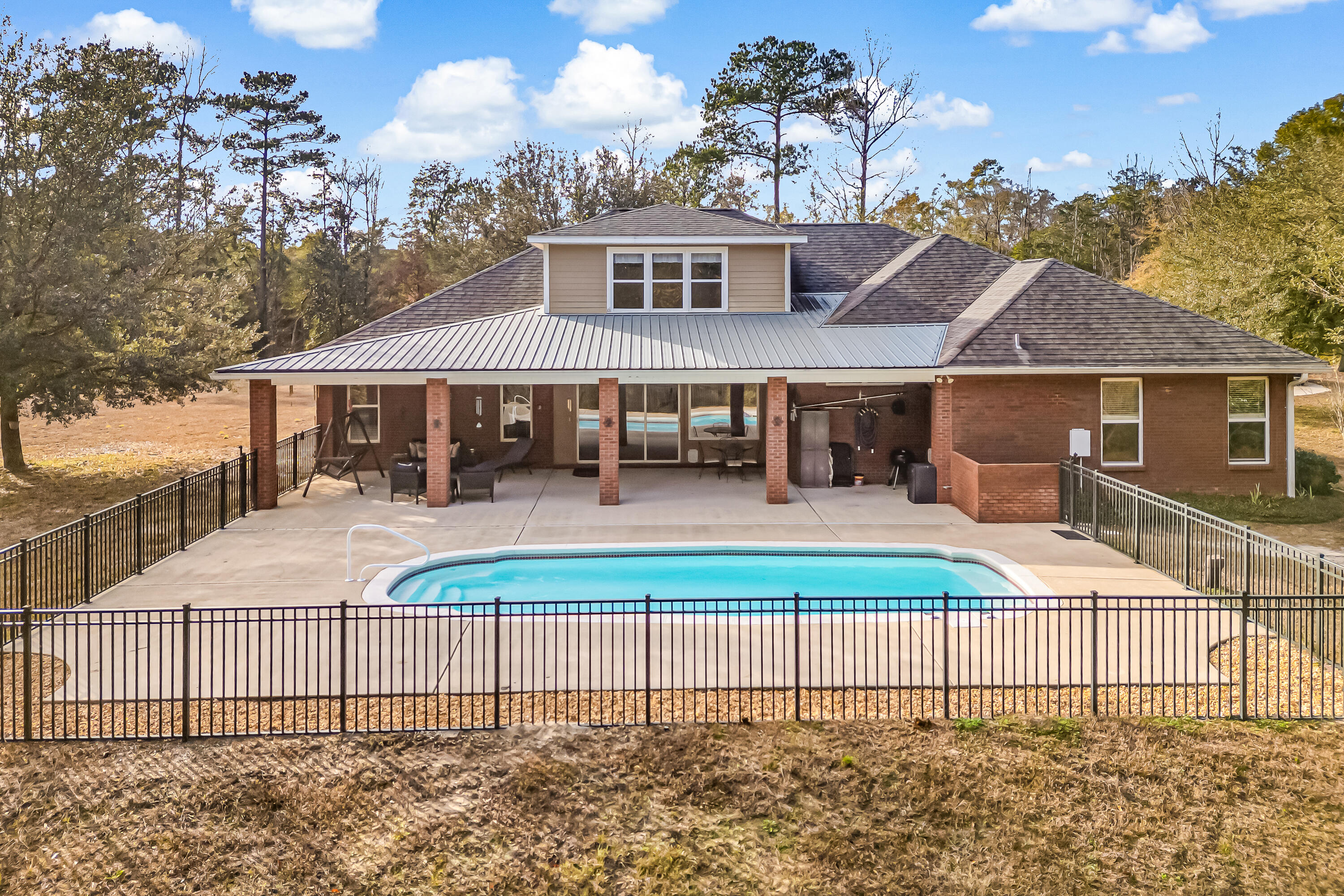 This custom built home offers exceptional craftsmanship and thoughtful design. Step inside to a grand entryway leading to a formal dining room and a dedicated office. The kitchen features custom maple cabinetry, granite countertops, a breakfast bar, and a walk-in pantry, overlooking the family room, Florida room, and sparkling saltwater pool. The split floor plan places three bedrooms on one side. With a MIL suite and a luxurious owner's suite on the other side of the home. Upstairs, a versatile fifth bedroom offers endless possibilities.  Enjoy the large driveway, 2 car attached garage and free standing 2 car garage with attached car port. 
Bring your horses or start your own mini farm, there is plenty of space for barns, riding trails and more. Enjoy the peace and privacy of no neighbors, nestled on 16+ private acres, this home provides the perfect blend of country living and convenience, just 5 minutes from DeFuniak Springs.  The best of both worlds. space, style, and serenity.