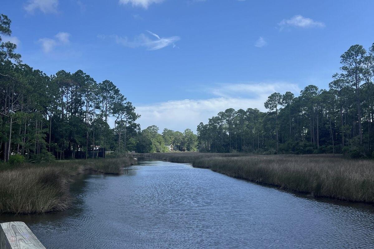 This oversized 0.34 acre waterfront lot is centrally located in Santa Rosa Beach, making it a great opportunity for a multitude of options.  Offering approximately 150 feet of water frontage, mature trees and direct bay access, this wonderful property presents an outstanding opportunity to create a custom home, an investment property or a pair of waterfront cottages in a great location with no HOA restrictions.
Framed by beautiful mature trees that provide natural shade and privacy, the homesite overlooks a protected bayou and a large marsh buffer, preserving tranquil views and enhancing the sense of seclusion. Spend afternoons fishing from the shoreline or set out on your kayak or paddleboard for a day on the bay with convenient direct water access.
Adding even more value, a water meter is already in place, allowing a substantial portion, if not all, of the tap fees for new construction to be abated. Whether your vision includes a spacious primary residence with a large yard, a large workshop or garage for your boats and trailers, or two waterfront cottages designed for short-term rental income, this property offers the space and versatility to bring it to life.
Ideally positioned to enjoy everything the Emerald Coast has to offer, this property is just eight minutes from Ed Walline Regional Beach Access and only one minute from Cessna Landing Boat Launch, making both beach days and boating adventures effortlessly accessible. Convenient access to Highway 331 and Highway 98 places shopping, dining, entertainment and neighboring coastal communities just a short drive away.
With generous waterfront frontage, direct bay access, valuable infrastructure already in place and no HOA, this is a great opportunity to secure an affordably priced waterfront homesite in the heart of Santa Rosa Beach.