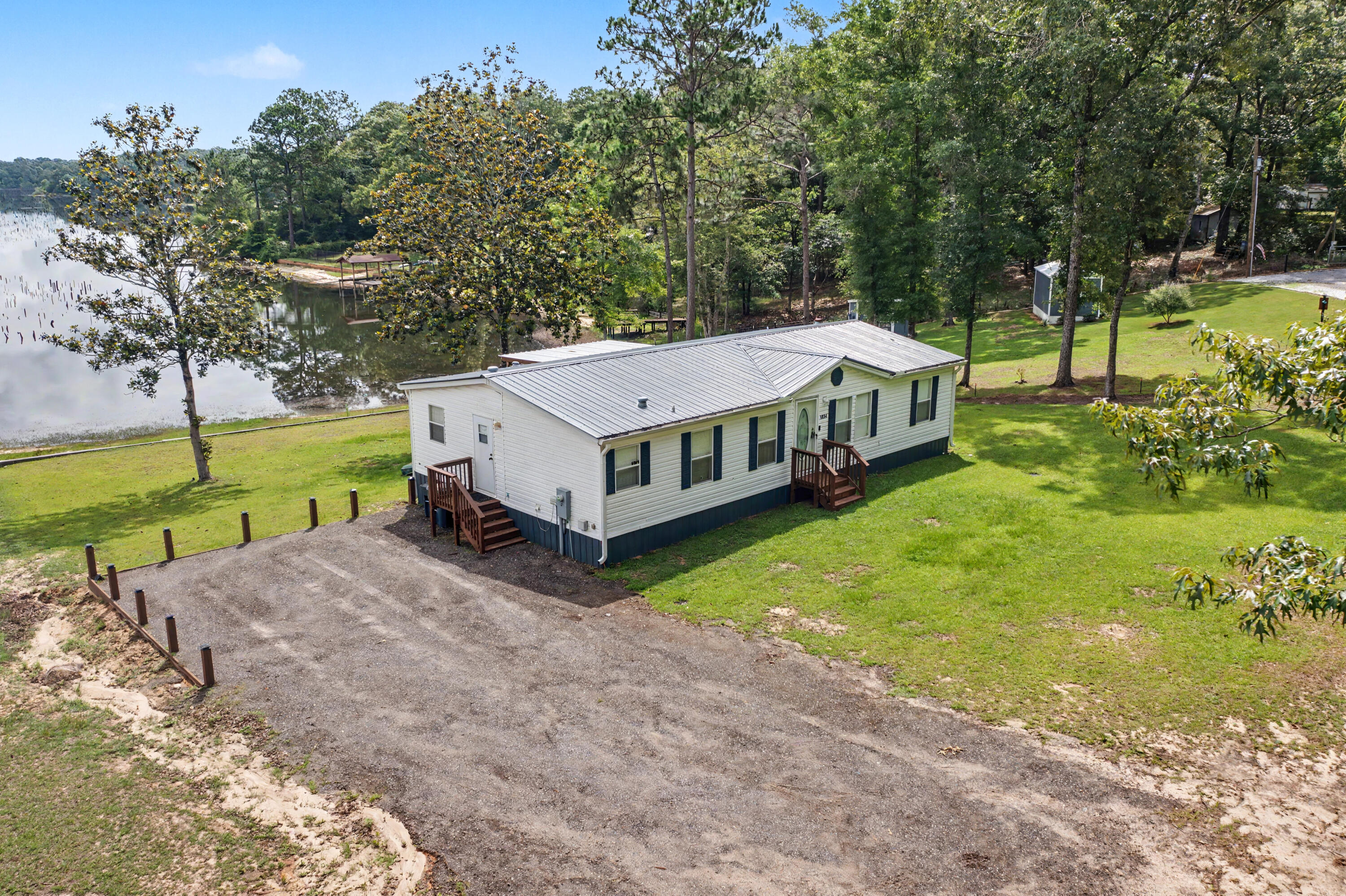 Welcome to your own private slice of paradise on sought-after Kings Lake Boulevard! Nestled at the end of a quiet street, this meticulously maintained waterfront home offers peaceful living with breathtaking views of beautiful Kings Lake -- a lake well-known for being fully stocked with fish and perfect for relaxing afternoons on the water. Inside, you'll find durable and stylish LVP flooring, and new carpet in the bedrooms, creating a seamless and modern feel. The home has been thoughtfully updated with a new roof and a new porches, giving you the perfect place to unwind while overlooking the sparkling lake views. Additional features include a full gutter system and irrigation system for easy maintenance and added convenience. Whether you're enjoying your morning coffee overlooking the water, fishing from your backyard, or simply soaking in the serene setting, this home truly offers the best of waterfront living.Tucked away for added privacy while still conveniently located, this Kings Lake gem is one you don't want to miss!