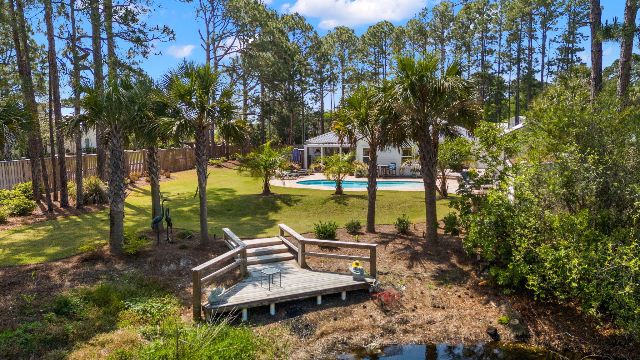Don't miss this special new buyer incentive: Seller is offering $20,000 toward buyer closing costs and prepaids. With an acceptable offer, seller will also fully renovate the kitchen, dining room, and laundry room, and install new flooring throughout -- giving buyers a rare chance to customize this coastal estate to their taste while locking in today's price. Experience a rare sense of privacy, tranquility, and investment potential at this coastal estate at 10 Fairway Drive. Ideally situated just minutes to the beach on a generous 0.58-acre corner lot, this property offers space between homes and a room to breathe feel that can be hard to find along the 30A corridor. Topped with a brand new custom-color metal roof (installed May 2026), this home arrives turnkey, fully furnished, and ready to enjoy immediately. 
The crown jewel of the estate is the expansive backyard coastal oasis, enclosed entirely by an 8-foot shadowbox privacy fence. Here you'll find a natural coastal dune pond -- a self-sustaining ecosystem stocked with bass, bream, and catfish, perfect for a quiet afternoon John-boat ride or a morning of fishing off your private dock. The grounds are rounded out by a resort-style heated pool, fire pit, mature landscaping, and white peach trees. Located just minutes to the beach in the exclusive non-HOA community of Santa Rosa Ridge, this home makes for a perfect primary residence or second home.