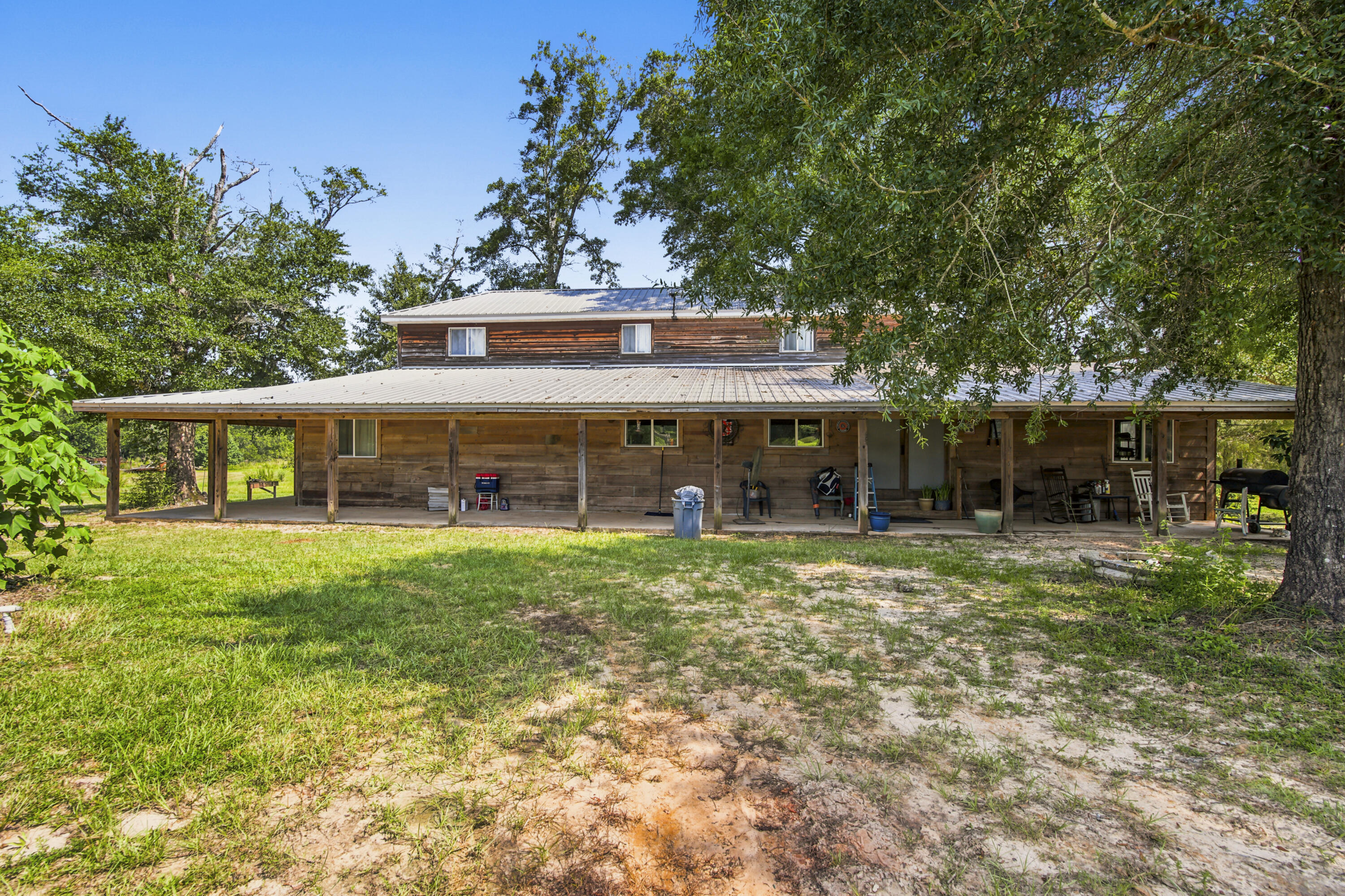 Discover the perfect blend of country living on this beautiful 80-acre property featuring approximately 30 acres of pasture and Eight-mile Creek flowing through the southern portion of the land. The 2,974 sqft two-story barndominium offers an open floor plan with a spacious kitchen, sit-at bar, and plenty of room for entertaining. The oversized primary suite features 2 walk-in closets and a large private bath. A second bedroom downstairs is ideal for guests or a home office. The oversized laundry room offers abundant storage and could also serve as a pantry or mudroom. Upstairs you'll find two large bedrooms and a full bath with tile floors and tiled walls. Relax and enjoy the peaceful surroundings from the covered wraparound porch that extends around three sides of the home. A large pole barn provides ample storage, with half enclosed offering potential for an office or additional living space. This property is ideal for farming, recreation, or your personal county retreat.