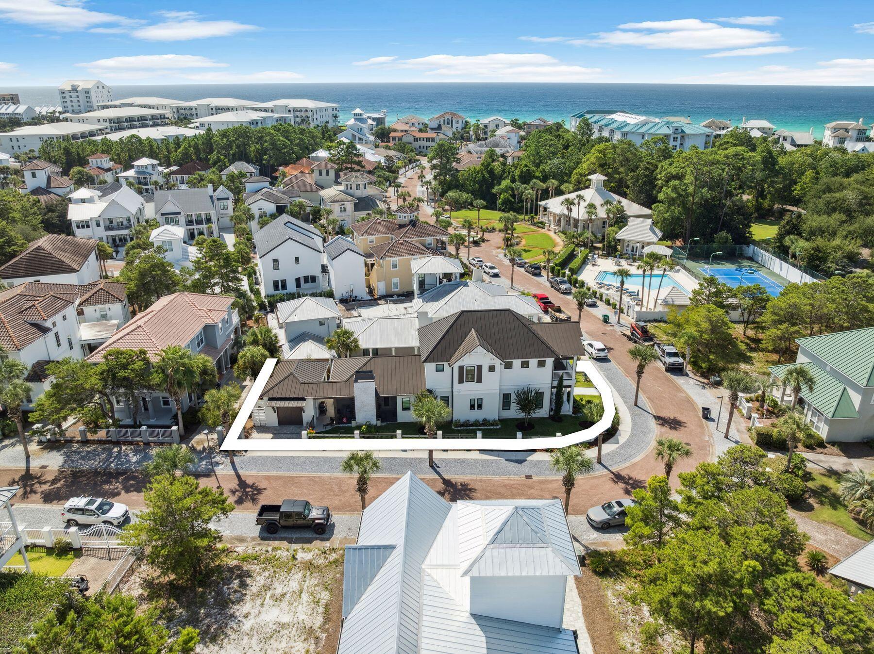 Welcome to 113 White Cliffs Drive, a stunning 2023-built coastal retreat in the sought-after Village of White Cliffs, a gated, Gulf-front community along Scenic Highway 30A in Blue Mountain Beach offering four bedrooms and a dedicated office. Designed with uncompromising attention to detail, this home blends timeless quality craftsmanship with modern convenience, offering both luxury and livability. Sitting on a large corner lot with a fully fenced yard—constructed of block and aluminum for durability—it's perfect for letting pets roam freely. The oversized one-car garage with coated floors adds function, while the screened-in porch with a brick gas fireplace creates a cozy gathering space year-round. Inside, thoughtful design is evident throughout. A welcoming two-story foyer leads to an open and flowing layout where the living, dining, and kitchen spaces connect seamlessly. The living room showcases beamed ceilings, while the gourmet kitchen impresses with a large center island, Quartz countertops, Thermador appliances including a gas range and oven, an additional Samsung dual-temperature built-in oven, convection microwave, wine refrigerator, trash compactor, and custom cabinetry with custom organization solutions. A large pantry provides even more storage. Conveniently located on the first level, the luxurious primary suite boasts vaulted pine ceilings, screened porch access, dual closets, and a spa-inspired en suite with quartzite counters, dual vanity, crystal hardware, and a wet room complete with a jetted tub surrounded by quartzite and a walk-in shower. The first level also includes a mud room with an ice maker and additional storage, a laundry room with sink and cabinetry, a powder bath with quartzite countertops, and a private office featuring custom storage and custom glass barn doors. Upstairs, three guest bedrooms provide comfort and privacy. A private suite offers dual vanities and a tub and shower combo, while the two additional guest rooms share a Jack-and-Jill bathroom. The versatile fourth bedroom with wet bar and balcony creates flexibility to be utilized as a den or additional sleeping space. Additional highlights include engineered hardwood and tile throughout, spacious attic storage with heavy-duty aluminum stairs, and advanced features such as smart home capabilities, Cat6 wiring, a Rinnai tankless water heater, irrigation system, and Live Oak Fiber internet. Beyond the home, residents of The Village of White Cliffs enjoy exceptional amenities including a private beach walkover with convenient bathrooms and a viewing deck, clubhouse with full kitchen and gathering spaces, a newly renovated fitness center, seasonally heated pool, and tennis courts with pickleball lines and lights. This exclusive, short-term rental-restricted community ensures a peaceful coastal lifestyle just moments from the best of 30A. 113 White Cliffs Drive is more than a home it's a statement of quality, comfort, and refined coastal living.