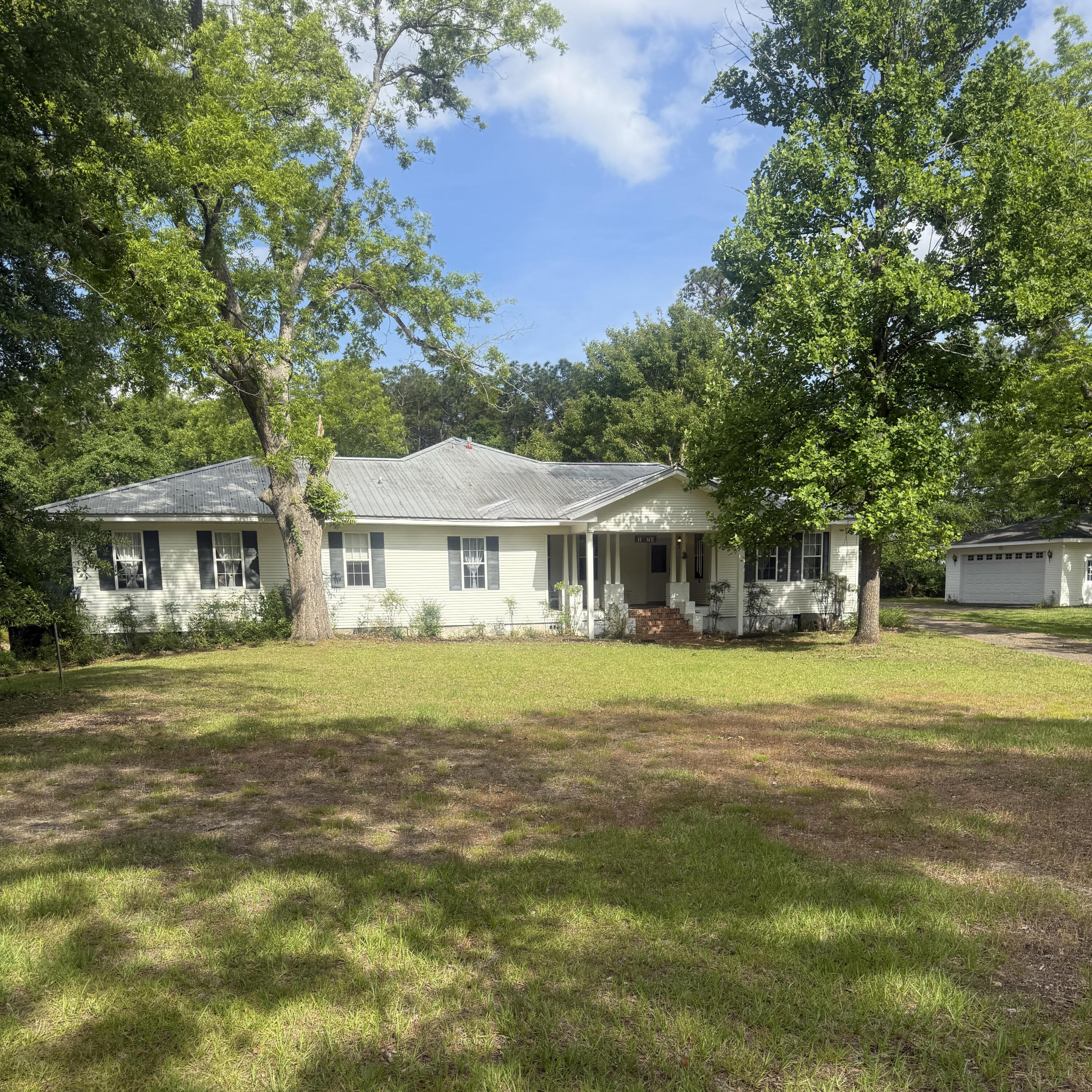 Warm timeless southern charm. This 8.8 acres property is country living in the city limits, minutes away from downtown Andalusia. This home features a large living space with custom features, large rooms, each of the 4 bedrooms have bathrooms. An office/library. The kitchen has all custom built cabinets. A wrap around porch perfect for relaxing, entertaining, and enjoying the peaceful country views of large shade trees framing the home and creating a park like atmosphere. The yard includes Pecan, Walnut, Crabapple, Oaks and flowering trees throughout. The property has a large barn, workshop and separate garage. Rare opportunity to own a piece of history with modern day space and versatility. Enjoy gardening, the birds, and hobbies as time slows down.