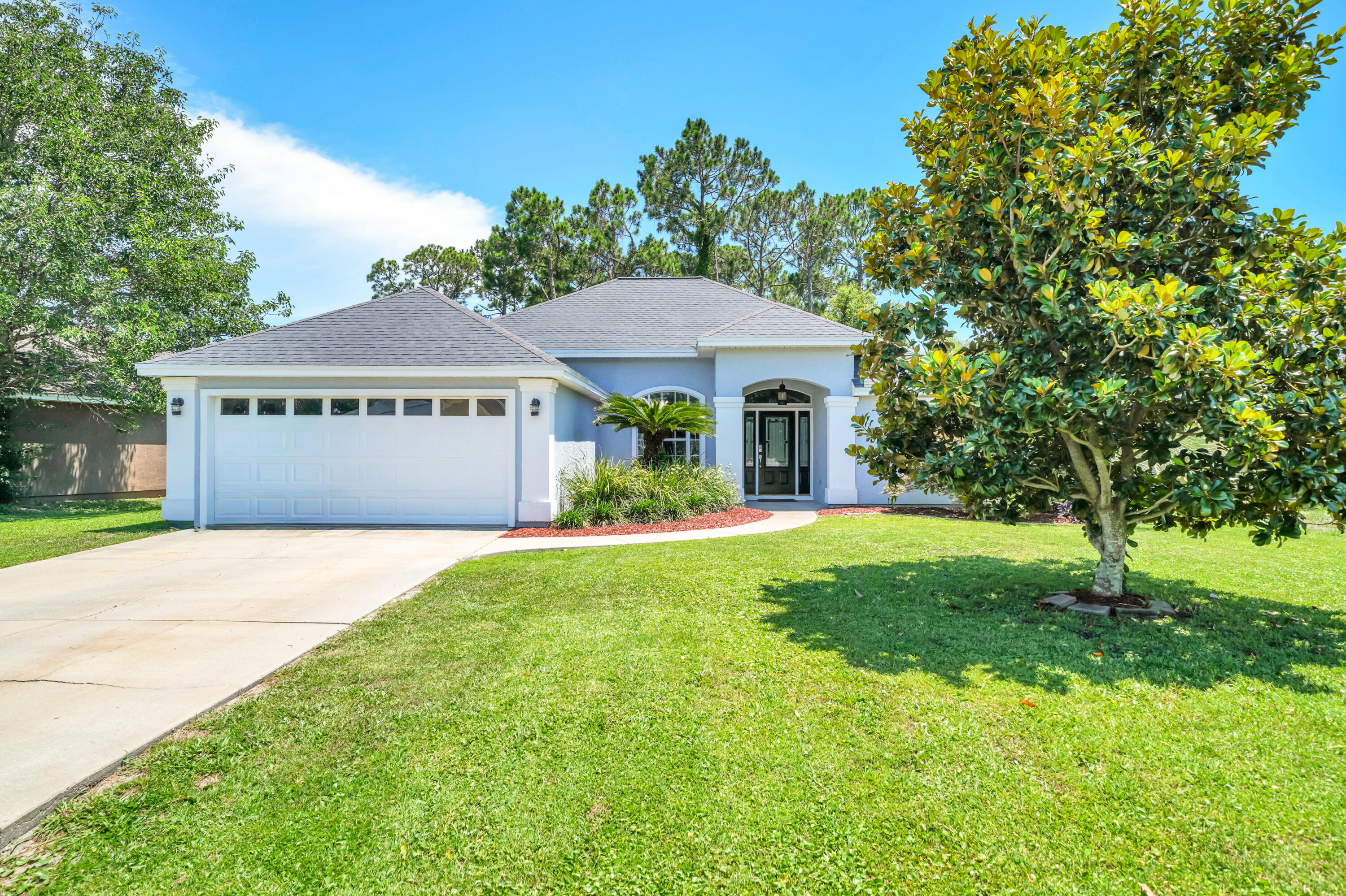 ***OPEN HOUSE! SAT, AUG 1, NOON-2PM*** Pride of ownership is taken to a whole new level in this beautiful residence in the Hidden Pines neighborhood of Panama City Beach. Lovingly and meticulously maintained by its owner-occupant for over 20 years, this immaculate home delivers a rare combination of pristine quality, thoughtful updates, and an unbeatable location with no HOA dues. From the moment you arrive, exceptional maintenance is evident inside and out. Major exterior updates provide long-term peace of mind, including fresh elastomeric paint and updated stucco work (2024), replaced front door glass and sidelights (2021), and a 2018 roof. 

Inside, 1,701 sq. ft. of carpet-free living space features soaring ceilings, crown molding, fresh 2026 interior paint, brand-new lighting and ceiling fans, plus beautiful COREtec Plus LVP flooring. In addition to the 3 spacious bedrooms and 2 full bathrooms, the home includes a flexible Florida/bonus room fitted with its own newly added exterior door (2025), making it an ideal home office, flex room, or private guest space. The heart of the home centers around a cozy fireplace and a beautifully revamped kitchen equipped with brand-new granite countertops (2026), a sleek quartz composite sink, an under-sink water filtration system (2025), modern stainless steel appliances, updated plumbing fixtures, a dedicated dining area, and a light-filled breakfast nook featuring a newly replaced exterior window (2026).  The primary suite serves as a true retreat with two walk-in closets, a double vanity, a frameless glass shower, a separate soaking tub, a newly added privacy window (2026), and upgraded toilet and plumbing fixtures.  

Outside, the property backs directly up to a peaceful, protected wooded preserve, providing a completely private backyard oasis with no rear neighbors. Enjoy the coastal breeze from your covered, screened-in porch, or take a scenic stroll along the community's convenient nature paths. Situated in a highly desired pocket of PCB just minutes from the Navy Base, premier shopping, local dining, and world-famous emerald waters, this meticulously updated home is completely move-in ready. Schedule your showing today!