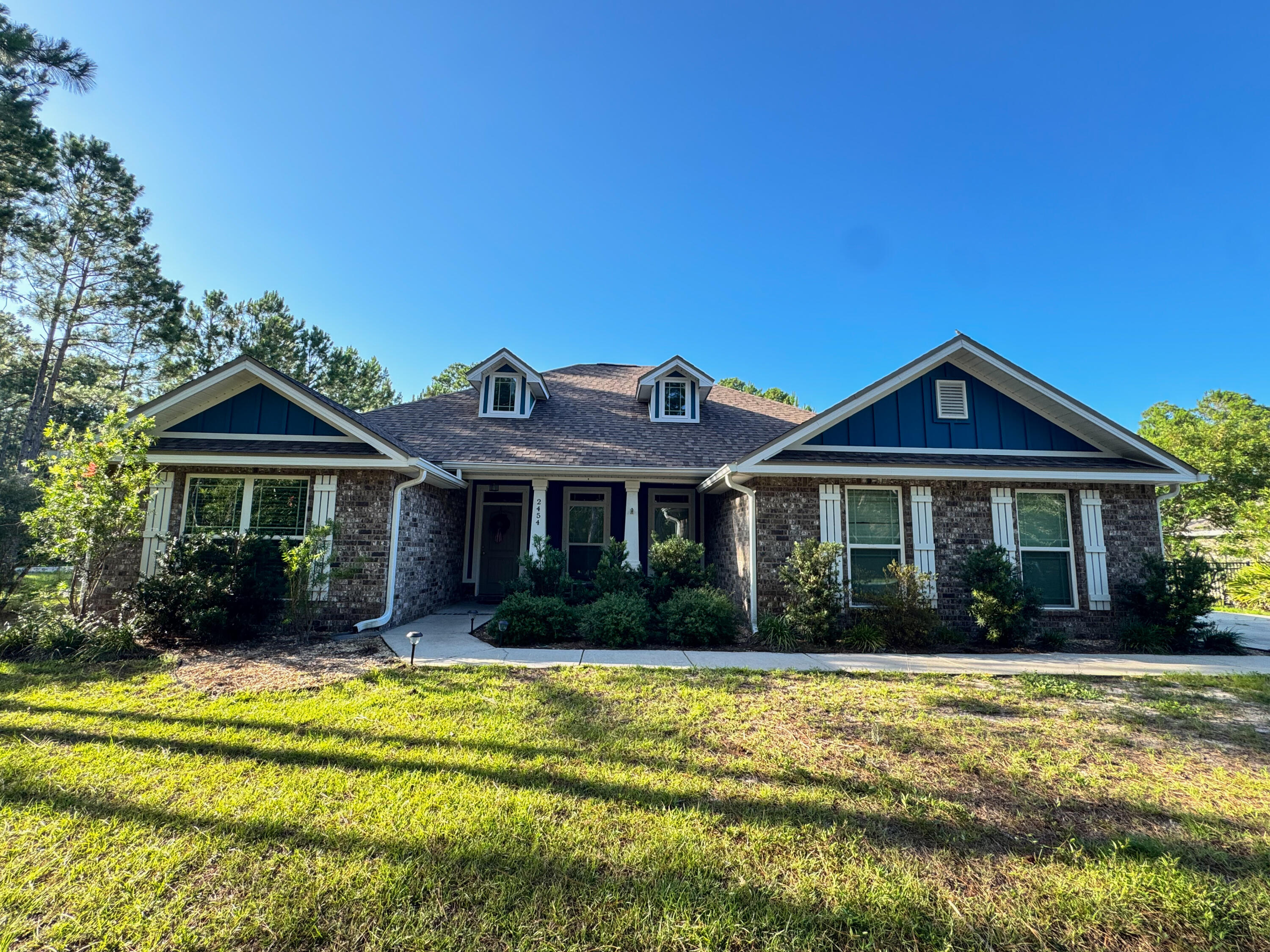 Beautiful craftsman Build on a huge Corner Lot  in Holley by the Sea! This gorgeous home sits on nearly 3/4 acres in a community with abundant amenities like a community room, boat launch, playground, and more! The inside features over 2,000 square feet including four bedrooms, two bathrooms, and an open living area, dining room, and kitchen. Tall, trey ceilings and plank tile floors flow throughout, highlighting the open concept, and large windows fill the rooms with natural light. The kitchen comes equipped with stainless appliances, rich wood cabinetry with soft close drawers, a mosaic backsplash, and granite counters that continue over the center island. Perfect yard for a pool and comes with a shed for storage.