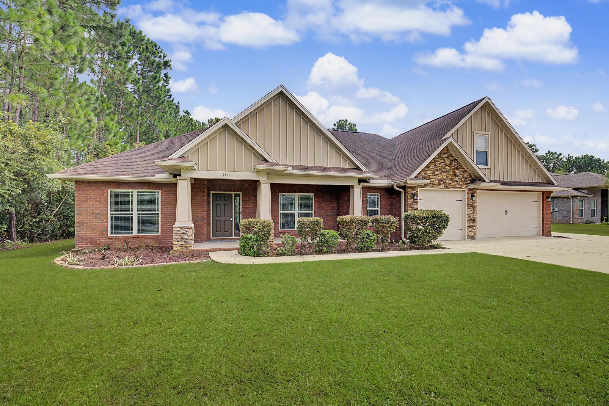 Experience refined coastal living in one of Navarre's most desirable communities. This exceptional 5-bedroom, 3.5-bath brick residence blends timeless architecture with spacious design, offering the perfect balance of elegance, comfort, and the Northwest Florida lifestyle.

A welcoming covered front porch leads into a light-filled interior where soaring tray and box ceilings, graceful archways, and a sophisticated neutral palette create an inviting atmosphere. The thoughtfully designed split floor plan provides privacy for the primary suite while offering flexibility for family and guests. Upstairs, a private fifth bedroom with its own ensuite bath and oversized walk-in closet is ideal as a guest retreat, executive office, or media room.

Designed for both everyday living and effortless entertaining, the open-concept great room flows seamlessly into the well-appointed kitchen featuring granite countertops, stainless steel appliances, abundant cabinetry, a breakfast bar, and an adjoining formal dining room for memorable gatherings.

The luxurious primary suite serves as a private sanctuary with an elegant double tray ceiling, spa-inspired bath, soaking tub, tiled walk-in shower, dual vanities, and an oversized walk-in closet.

Outside, the covered lanai overlooks a generously sized backyard with ample space for a future pool, outdoor kitchen, or simply enjoying Florida's year-round sunshine. An extended driveway provides generous parking for family and guests. Ownership in Holley by the Sea offers access to one of Northwest Florida's premier recreational communities. Residents enjoy championship-style amenities including eight clay tennis courts, three swimming pools, a fitness center, boat launch with access to Santa Rosa Sound, walking paths, playgrounds, and a vibrant community center. Just minutes from the sugar-white beaches of the Gulf of Mexico, this home delivers an exceptional blend of coastal elegance, resort-style amenities, and everyday convenience.
