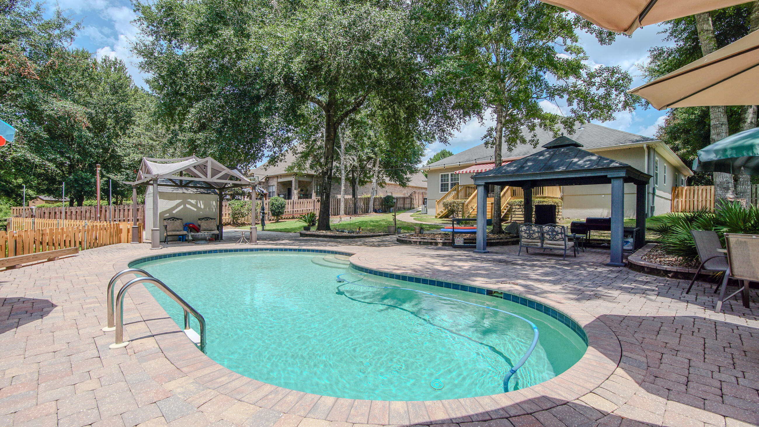 Welcome to 158 Whispering Way in the highly desirable Hammock Bay community of Freeport, Florida. Situated on an oversized 0.41-acre homesite backing to protected preserve land, this beautifully updated 5-bedroom, 3.5-bath home offers the perfect combination of privacy, comfort, and resort-style living. With 2,824 square feet of thoughtfully designed space, this home was built for both everyday living and entertaining. Inside, you'll find a spacious and functional layout with generous living areas, flexible bedroom space, and tasteful updates throughout. Recent improvements include a new roof, freshly painted stucco exterior, hurricane shutters, a brand-new tankless water heater, and a whole-house generator for added peace of mind. Step outside to your own private backyard retreat featuring a heated inground saltwater pool, brand-new deck, basketball court, fully fenced yard, and backyard storage shed. With no rear neighbors and peaceful preserve views, this outdoor space offers the ultimate setting for relaxing, entertaining, or enjoying quiet evenings at home. Located in one of Freeport's premier master-planned communities, Hammock Bay offers an unmatched lifestyle with exceptional amenities including multiple resort-style pools and clubhouses, a state-of-the-art fitness center, tennis, basketball and pickleball courts, miles of walking and biking trails, dog parks, playgrounds, community events, seasonal markets, and the stunning Lake Club overlooking the bay. Conveniently located just minutes from the beaches of 30A and South Walton, shopping, dining, and top-rated schools, this move-in-ready home delivers the best of Florida living in one of the area's most sought-after neighborhoods.