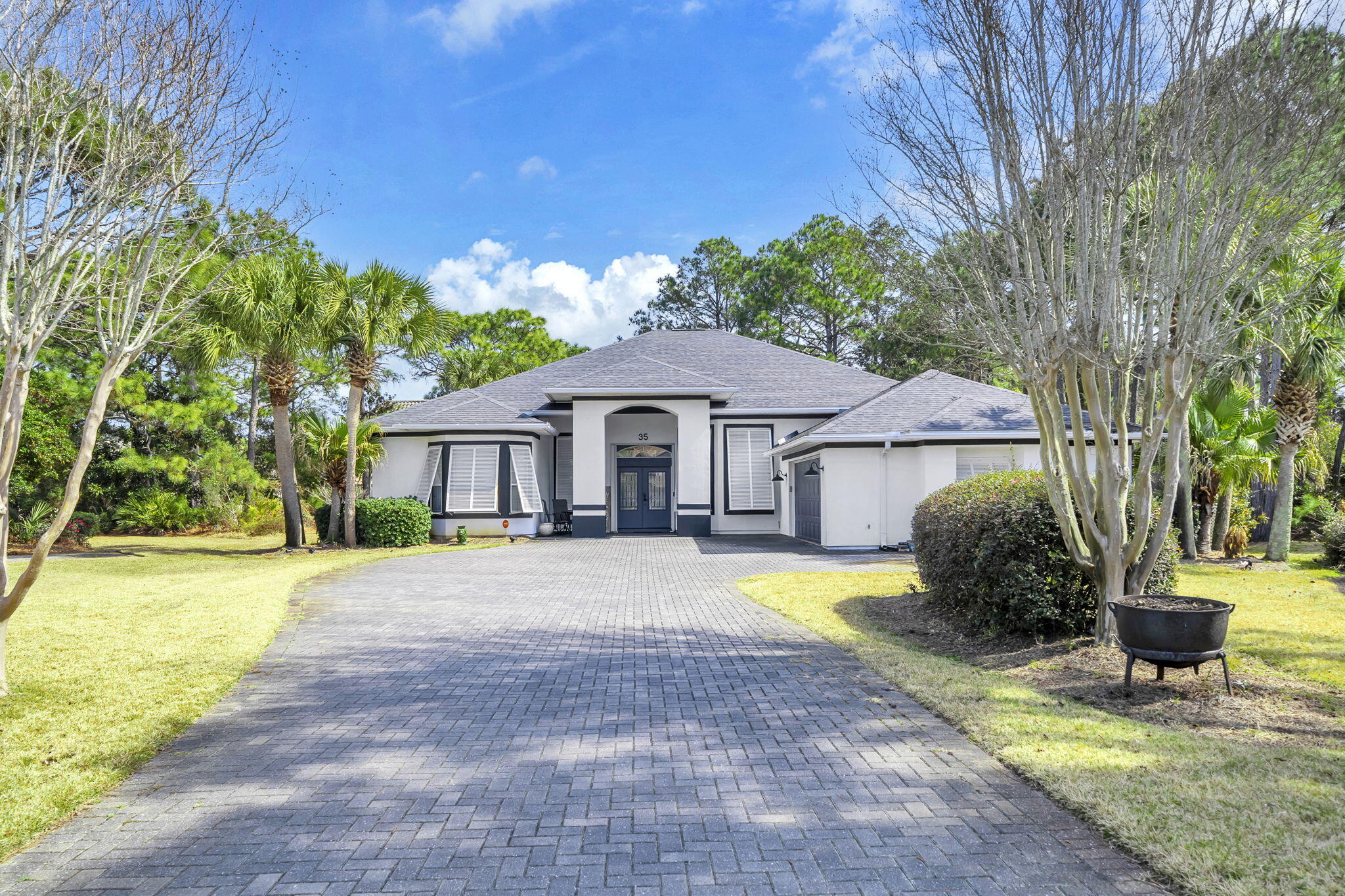 Set within the prestigious gated golf course enclave of Emerald Bay in Destin, this Mediterranean-inspired 3-bedroom, 2-bath residence with a versatile flex room offers an exceptional blend of privacy, sophistication, and resort-style living. Positioned at the end of a quiet cul-de-sac and bordered by a protected conservation area, the property delivers a serene, secluded setting just minutes from Destin's renowned beaches, dining, and shopping.

French doors open to an elegant formal living room, where soaring ceilings and a wall of sliding glass doors crowned by dramatic transom windows flood the space with natural light. These architectural details frame tranquil views of the private screened-in saltwater pool, creating a seamless indoor-outdoor connection. The adjacent family room, anchored by a gas fireplace, flows effortlessly to the covered back porch and pool terrace--ideal for refined entertaining or relaxed evenings outdoors. The primary suite occupies a private wing with direct pool access and a recently updated spa-inspired bath featuring a soaking tub set within a bay window with granite ledge, a custom glass-enclosed walk-in shower, and an expansive double vanity with generous storage.

The flex room offers exceptional versatility and can serve as a home office, media room, fitness space, or additional guest accommodations. Fresh neutral interior finishes enhance the home's refined aesthetic, while the oversized garage with built-in cabinetry and work surfaces adds exceptional functionality. A well-fed irrigation system supports lush landscaping, and storm shutters, storm doors, and a full-house generator provide peace of mind.

Residents of Emerald Bay enjoy an exclusive golf course lifestyle in one of Destin's most desirable communities--offering elevated coastal living just moments from the emerald waters of the Gulf.