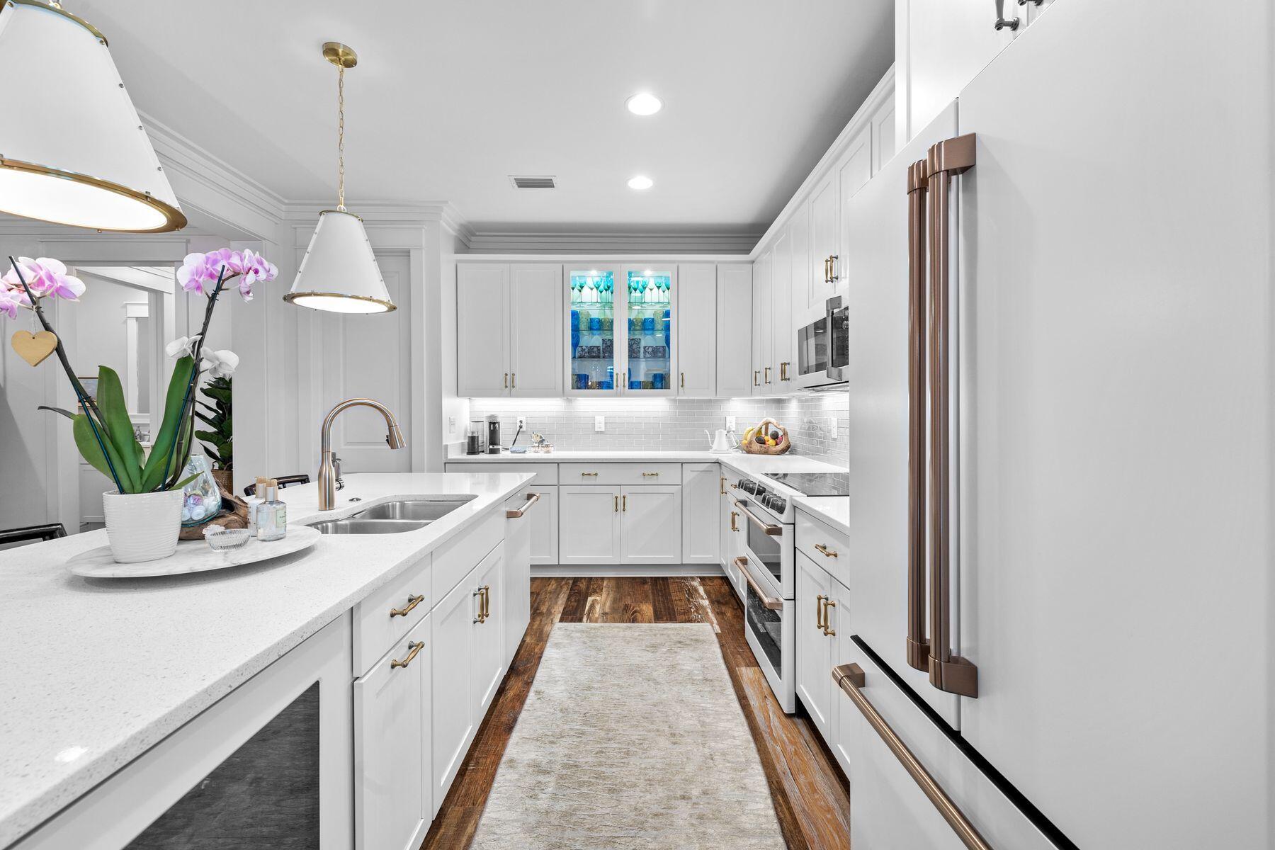 Positioned on a premium corner lot in the coveted Winter Garden phase of Watersound Origins, this beautifully appointed Huff-built home offers refined comfort surrounded by lush, mature landscaping. Designed for effortless single-level living, the 2,616-square-foot layout features four bedrooms, three and a half bathrooms, and a dedicated office or flex space.
Inside, the heart of the home centers around a thoughtfully designed kitchen featuring quartz countertops, custom cabinetry, and a new GE Café Series appliance suite — complete with induction cooktop, double ovens, wine and beverage fridge, dishwasher, and refrigerator. Updates continue throughout with stylish new lighting in the kitchen, dining area, and foyer. The open-concept design seamlessly flows into the living and dining spaces, while a screened porch equipped with Bromic heaters and fenced backyard provide inviting areas for outdoor relaxation and entertaining. The primary suite includes a custom California Closets upgrade, enhancing both organization and luxury. The home's location, just one block from the clubhouse, also provides easy access to a resort-style pool, playground, and fitness center.

Nature enthusiasts will appreciate the scenic trail located directly behind the home, offering both privacy and convenient access to the community's extensive pathways that connect to Watersound Commons. Residents enjoy an active, vibrant lifestyle with tennis and pickleball courts, a Davis Love-designed executive golf course, and year-round neighborhood gatherings. Nearby, the Monarch Art Trail and a growing array of shops, restaurants, and weekly farmers markets add to the community's appeal.

Set on a .19-acre corner lot within one of the most desirable non-short-term rental communities on the Emerald Coast, this home presents an exceptional opportunity to enjoy the best of Watersound Origins living, where natural beauty and modern convenience meet in perfect harmony.