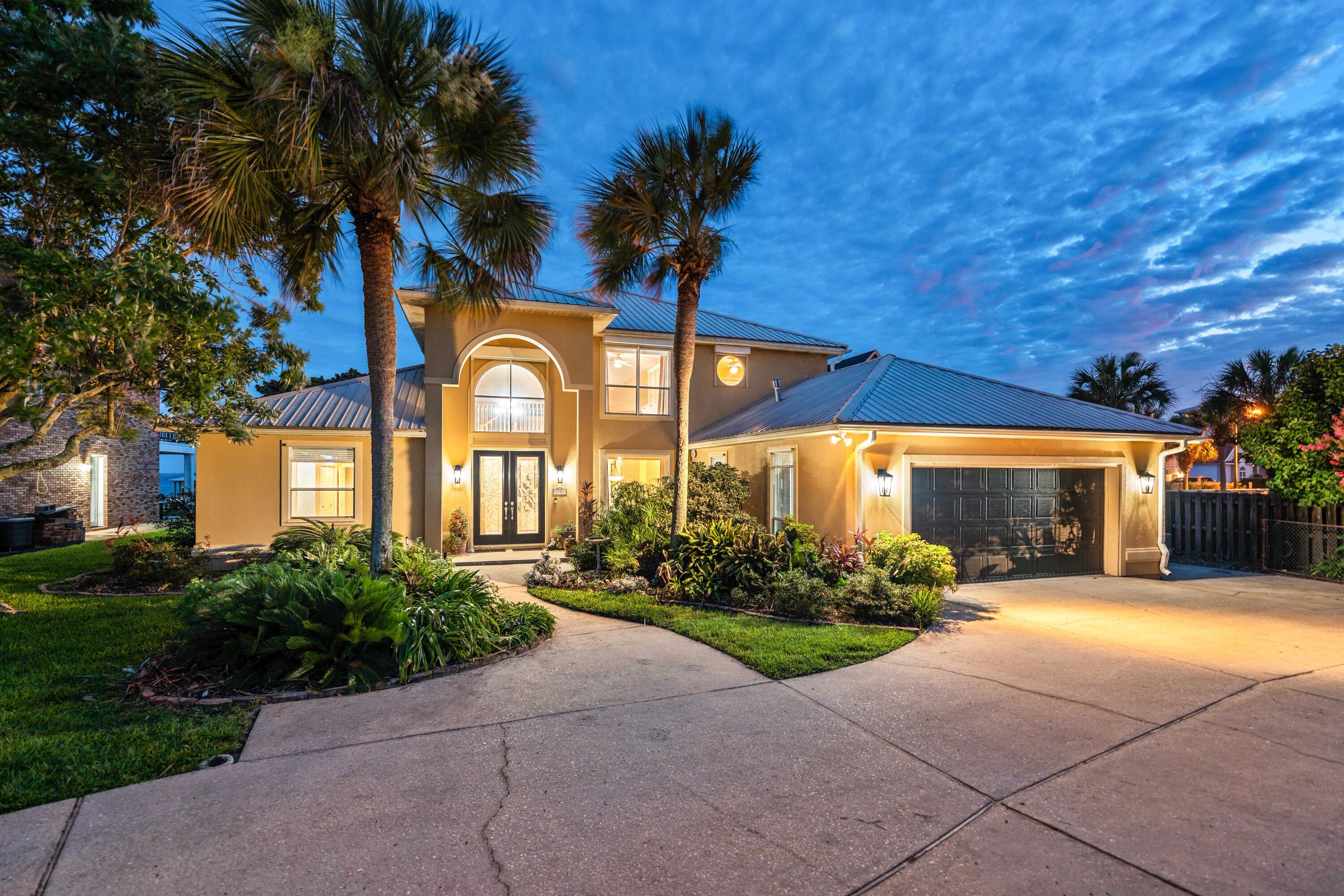 Ninety-three feet of Santa Rosa Sound frontage unfolds before you the moment you arrive. A 300-foot private dock stretches toward open water, a covered boathouse waits at its end, and a screened-in pool offers a front-row seat to the Sound -- all within Flood Zone X, the federal government's lowest-risk flood classification. 

This is not a compromise. This is the waterfront life, fully realized, on one of Navarre's most coveted sound-front lots.
Set on a sound front lot, 1901 Catamaran Dr is a custom executive residence where soaring 18- and 20-foot ceilings frame uninterrupted water views, and every detail has been considered with intention. The chef's kitchen commands the main level -- outfitted with a natural gas range, warming drawer, dedicated ice maker, wine fridge, trash compactor, dual prep stations, and a walk-in pantry with floor-to-ceiling shelving -- all while framing live views of Santa Rosa Sound. Bar seating for four. A formal dining room and casual dining area for every occasion.

The primary suite is a private sanctuary: bamboo wood floors, a dedicated sitting area, direct patio access, a garden tub, a separate tile shower, dual vanities with ample storage, and his-and-hers closets. The screened pool deck offers a front-row seat to the Sound, with an 8-foot-deep pool and a poolside half bath just steps away.
 Elsewhere: a gas fireplace in the great room, built-in speakers throughout communal spaces, porcelain tile, central vacuum, and a 2nd-floor flex space with custom built-ins. Auto hurricane shutters, full-perimeter storm protection, gutters, seawall, riprap, and a private sandy beach area.

Waterfront & Outdoor 
93 ft of Santa Rosa Sound frontage | 300-ft private dock with covered boathouse | Seawall, riprap, and private sandy beach area | Soundfront screened-in pool -- 8 ft max depth | Poolside half bath | Oversized circle driveway with parking for 6+ vehicles | Dedicated boat and/or RV parking on west side | Master gardener-designed landscaping | Well water irrigation system

Garage & Utility 
2-car garage with workbench and shop sink |  Central vacuum throughout | Natural gas range and gas dryer | Tankless water heater | All smoke detectors dual-certified (CO)

Kitchen 
Natural gas range | Warming drawer | Dedicated ice maker | Wine fridge | Trash compactor | Main sink and prep sink | Bar seating for 4 | Formal and informal dining areas | Large walk-in pantry with full surround shelving | Sound views from the kitchen

Interior 
18-ft entry foyer ceiling | 20-ft great room ceiling | Porcelain tile throughout main living areas | Bamboo wood floors in primary suite | New carpet -- under 18 months | Gas fireplace | Built-in speakers in communal areas | Uplighting and under-cabinet lighting in kitchen | Kick lighting in primary bath | 2nd-floor flex space with built-in cabinetry and shelving | Split bedroom floor plan

Systems
Tankless water heater | Auto hurricane shutters on two high windows | Storm shutters on all windows | Full gutters | Natural gas (range, dryer, fireplace, water heater)

Location 
8 min to Navarre Beach | 15 min to Gulf Islands National Seashore | 40 min to Destin-Fort Walton Beach International Airport | 45 min to Pensacola International Airport