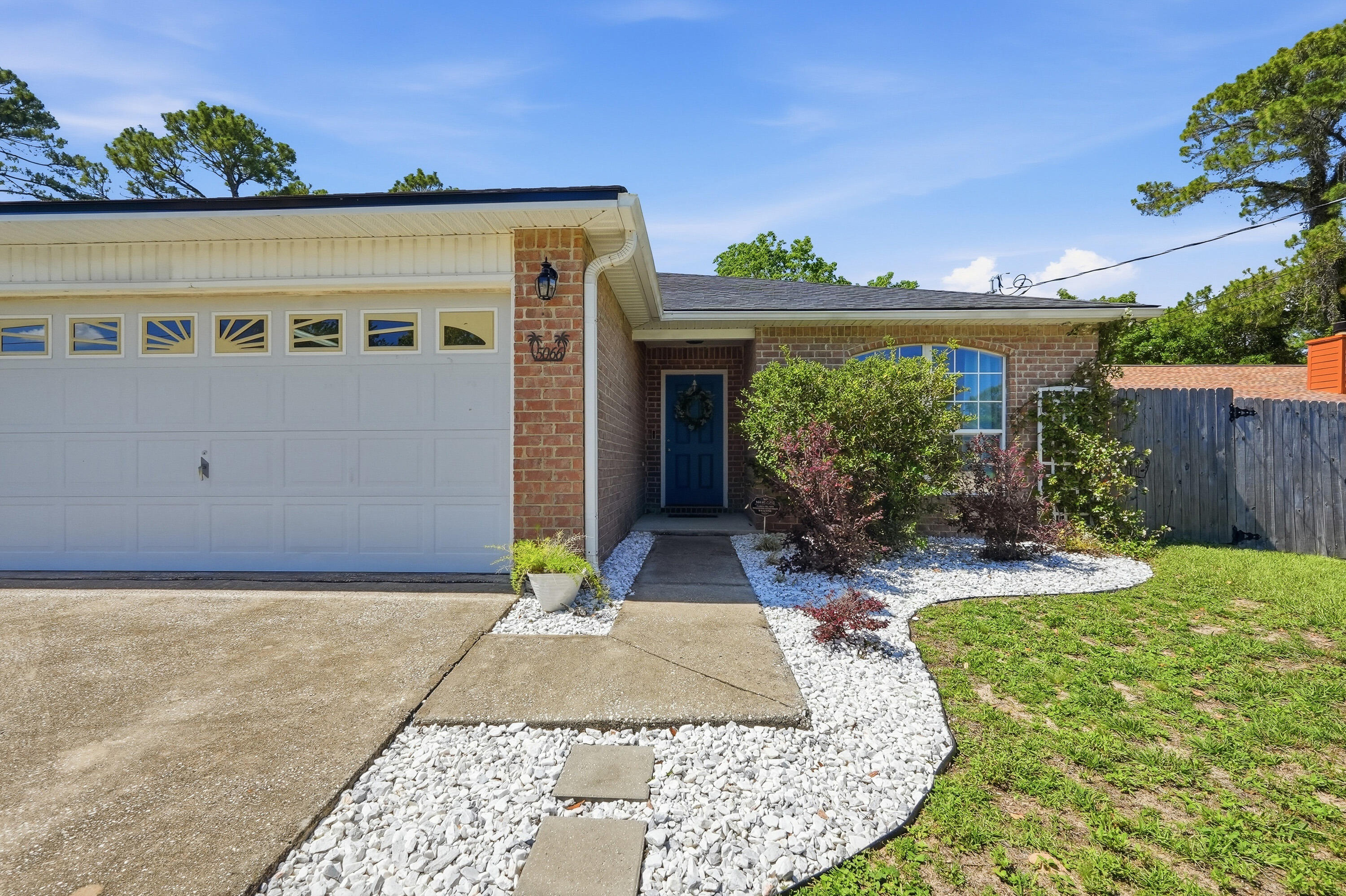Welcome to this beautifully maintained 3BR/2BA home offering comfort, style, and thoughtful upgrades throughout! From the moment you arrive, you'll notice the charming curb appeal with tasteful landscaping, fresh rock beds, and inviting front entry details. Inside, the open and airy floor plan features durable flooring through the main living areas, spacious bedrooms, and abundant natural light. The kitchen opens seamlessly to the living and dining spaces, making entertaining easy, while the private primary suite offers a large walk-in closet and spacious bath with double vanities. One guest bedroom features an elegant chair rail accent, adding extra character and charm.
Step outside and enjoy the backyard retreat complete with new French doors featuring built-in blinds, an extended and painted concrete patio, covered grilling area, additional entertaining space, and a fully fenced backyard surrounded by mature trees for added privacy. The garage has also been upgraded with custom wooden shelving and a workbench for added storage and functionality. This move-in ready home blends indoor comfort with outdoor living and is conveniently located near shopping, dining, schools, and the beautiful white sandy beaches.