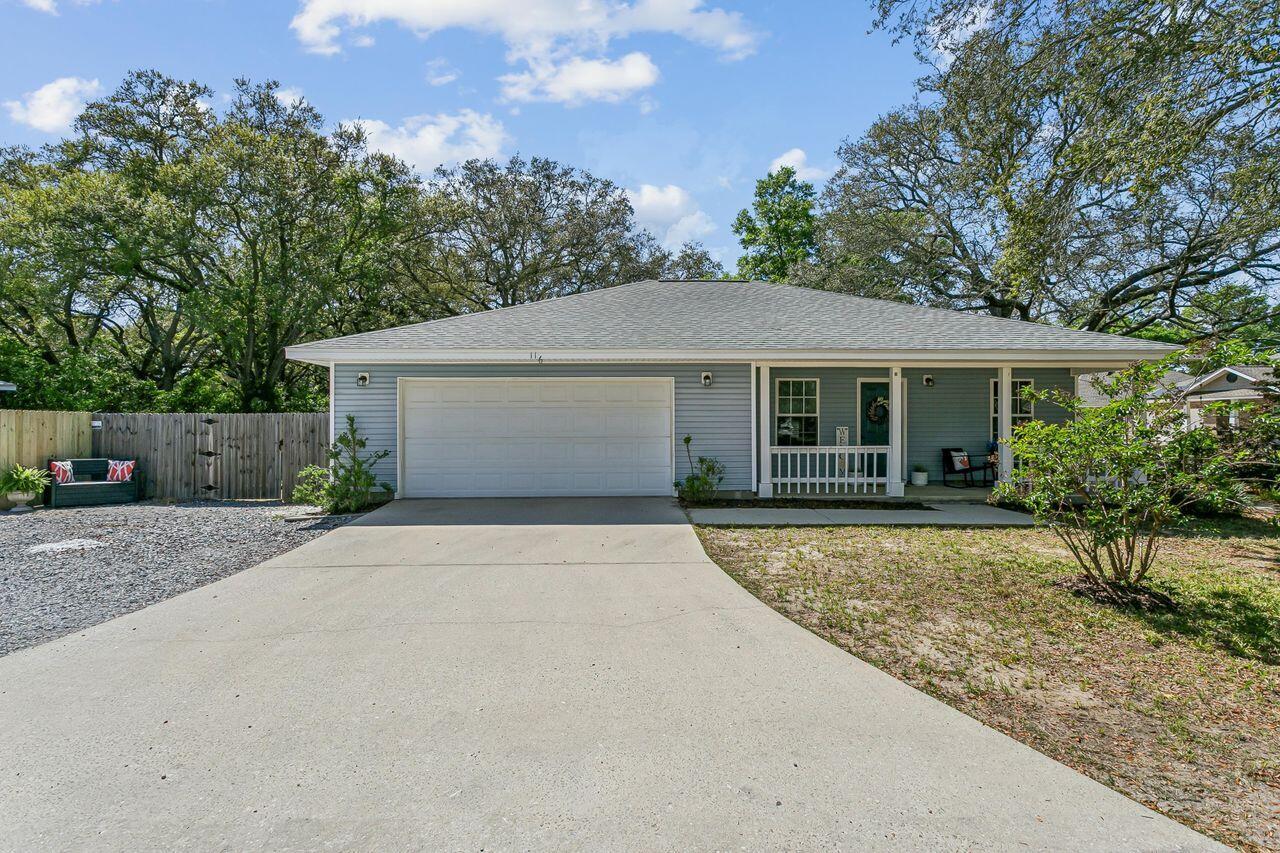 Coastal cottage charm meets everyday convenience in this delightful 3BR/2BA offering  comfort and privacy in the heart of Niceville! Enjoy your morning coffee on the inviting front porch, perfectly framed by the most majestic oak trees. Step inside to an open concept living area with LVP and tile throughout that connects to the kitchen and features newer stainless steel appliances and a huge breakfast bar that overlook both the living room and dining area, perfect for family dinners and entertaining! The desirable split bedroom floor plan provides an enormous owner's retreat with on suite bath, while the 2 additional bedrooms are well-sized and versatile perfect for guests or home office. Step out back and fall in love with a private paver patio offering extended outdoor living space surrounded by mature trees, lush landscaping, dedicated grill pad, and a beautiful courtyard perfect for the plant enthusiast! Additional highlights include an oversized garage, and a double back-gate entrance, ideal for storing boats, trailers, ATVs, or creating your outdoor workshop area. This home truly checks all the boxes, and is just minutes from top rated schools, local dining, shopping, Eglin AFB and the beautiful Emerald Coast beaches. Don't miss your chance to make this beautiful home yours today! Welcome Home!!