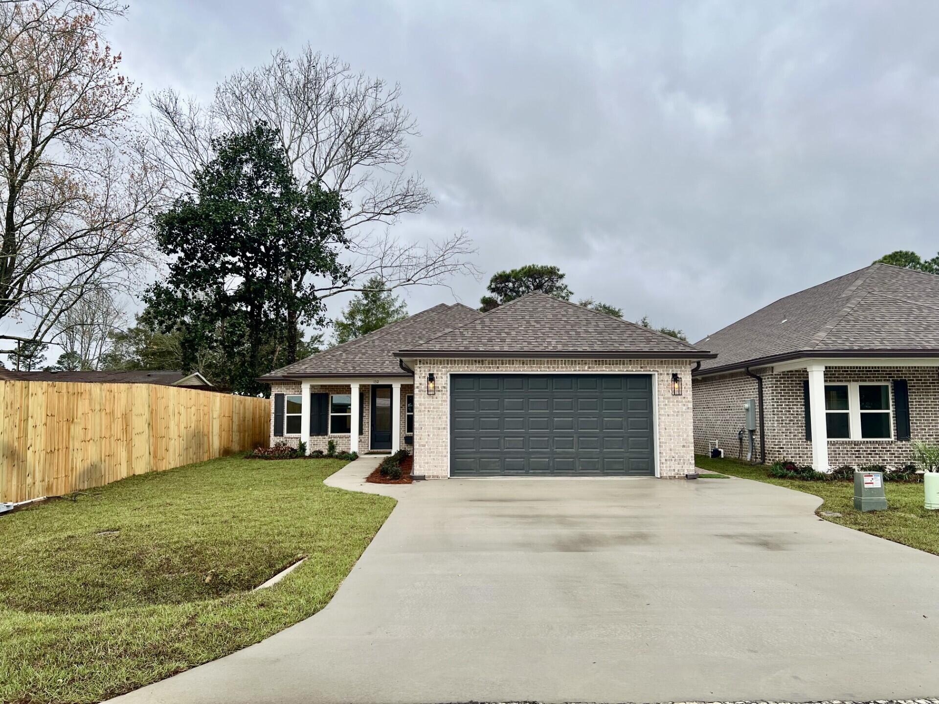 Stunning craftsmanship with southern charm in this new construction, all-brick, 4-bedroom, 2-bath home. This modern home features 1,905 sq.ft. with high-end custom finishes and exceptional detail. Get settled into a neighborhood less than 2 miles East of Bluewater Bay and the Mid-Bay Bridge surrounded by new construction! This move in ready home blends timeless quality with today's most desired features, creating a home that is as functional as it is beautiful. Entering the home, you have an oversized foyer that immediately sets the tone for the custom finishes found throughout. Premium LVP flooring throughout the entire home, paired with crown molding and reverse trey ceiling with lighting, providing a seamless aesthetic. Enter into the spacious living room with an open  concept and an abundance of natural light with large high-impact windows, neutral finishes and modern lighting. Additional features include a floor outlet in the family room, perfect for lamps or phone chargers without obstructing walkways and the reverse trey with custom lighting with a remote providing a color choice for every season. The kitchen is a true show-stopper, designed with both style and functionality. Featuring white maple shaker cabinetry with soft-close drawers, a farm sink, white ceramic back-splash, quartz countertops, steele Whirlpool appliance package and a large walk-in pantry. The oversized 8ft island and the 6ft coffee bar add the perfect finishes! As you enter the spacious primary suite, you're greeted with natural light and you'll love the reverse trey with custom changeable lighting. Especially in the evening! The spa-like bathroom is beautifully accented with a 6ft soaking tub with shiplap accents, custom led lighting behind the mirrors with changeable colors. A custom-built full-length mirror and the spa-like shower features a built-in bench, rain head, front sprayer and a handheld sprayer conveniently placed beside the bench. Custom shelving makes the walk in closet perfect for organization. This split floor plan provides two more bedrooms and another full bath. Laundry, you will actually want to do the laundry, with a custom folding table with quartz countertop, and built-in shelving. When you want to relax, and rewind, the back yard is the place! You'll enjoy a screened in porch with ceiling fan, flood lights on each end of the house and an extra paver pad across the back of the home for a full patio set and grill. Maintenance is easily obtained with this fully sodded yard, sprinkler system that works off a separate well and a 8 ft. privacy fence with gutters installed. Theres an alley road for these homes that give an entrance to the back yard as well. A double gate has been installed on the back right side, ideal for ATV's, jet ski or a trailer. For energy efficiency, the builder has installed upgraded spray foam in the roof. You will also enjoy the storage above the garage along with the upgraded epoxy garage floor. This builder takes great pride in his homes and it shows! Five new homes are under construction. The builder is offering $10,000.00 towards the buyers closing cost, doc stamps on the deed, split title insurance and all title related fees. Restaurants, boat launch, Eglin Air Force Base, Special Forces, Emerald Coast beaches, shopping, hospitals and more are very close. Call today for a viewing, and Welcome Home
