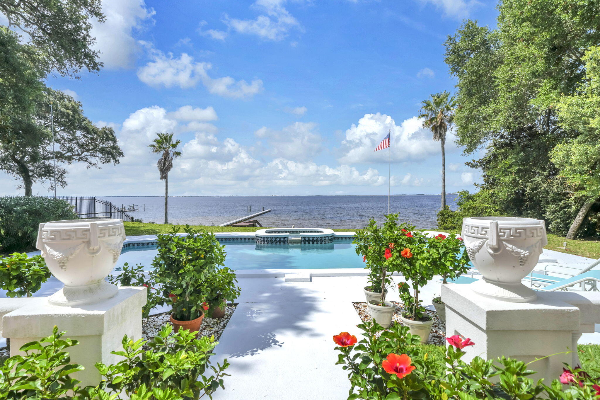 The incomparable setting for this elegant estate will surprise and delight you. With an expansive southern view of Choctawhatchee Bay including Destin harbor to the east, Okaloosa Island dunes to the south and Fort Walton Beach bayous to the west you are wrapped in beauty. 24 feet above the bay, your mind will be at ease as you live among graceful live oaks and coastal breezes. A private driveway delivers you into the serenity of this well-maintained home on .95 acres of land. Every living area takes advantage of the waterfront including a formal dining area and eat-in kitchen with a gas fireplace. The downstairs, large primary bedroom  includes a generous sitting area and library with full-length windows to enjoy the views. The second floor includes two spacious bedrooms. Walk-in attic provides convenient storage. The detached 3+car garage is connected by a bricked, shaded courtyard. The heated pool and hot tub take full advantage of the scenery. No HOA fees and no required flood insurance are added savings. Adjacent to Shalimar Pointe, you can drive to a golf course, tennis center and marina by golf cart. 10 minutes from Destin-Fort Walton Beach airport, you don't even cross a bridge to find home. You won't fight Destin or South Walton traffic. Property like this is both rare and rarely available. Make an appointment today to experience this exceptional place and secure your new home on the exquisite, sparkling waters of the Gulf Coast.