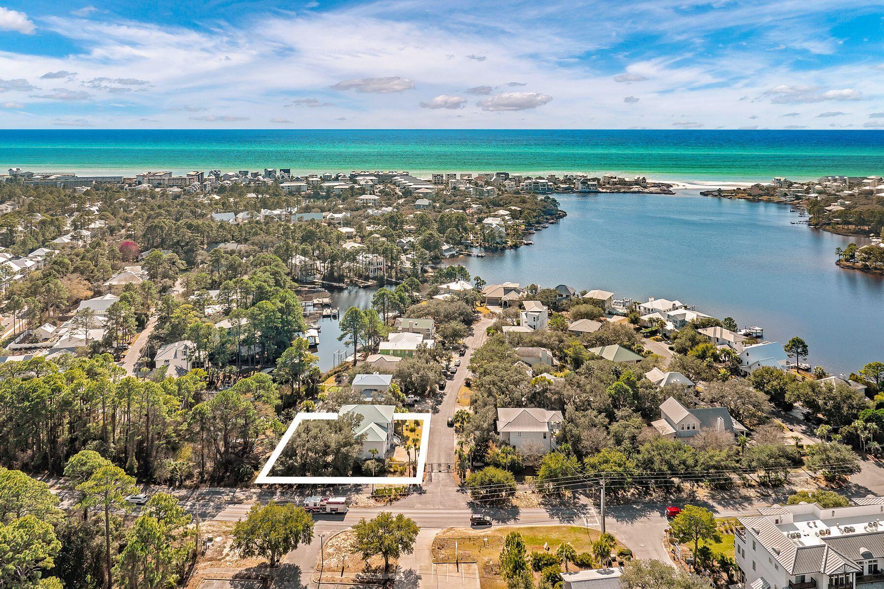 Set behind the gates of a quiet looping drive, this fully renovated lakefront home offers a way of living that feels both relaxed and elevated. Updated from top to bottom in 2020, the residence pairs designer finishes with an easy coastal rhythm centered on the water, the trees, and the ability to step outside and simply go.
The main living space is light-filled and open, anchored by a chef's kitchen designed for real life and effortless entertaining. Dual custom islands create space to gather, prep, and linger, while quartz countertops, a gas range with pot filler, and upgraded stainless steel appliances bring form and function together. The flow from kitchen to living area feels natural and inviting, whether hosting friends or settling in after a day on the lake. The primary suite is a true retreat, offering calming water views, a private balcony, and a spa-inspired bath that feels removed from the everyday. Upstairs, two additional bedrooms and a full bath provide comfortable accommodations, while the ground-level studio adds flexibility for guests, work-from-home needs, or a kids' hangout.

Outdoors is where this home truly shines. A tiered backyard framed by mature oaks opens to multiple porches and a private dock, making it easy to load a paddleboard, pack a cooler, and glide across the lake toward the beach or linger for sunset drinks on the water. The setting feels peaceful and established, with a sense of privacy that is increasingly rare.

Life here extends beyond the property lines. Neighbors gather for cookouts, boat parades mark the Fourth of July, seasonal paddleboard traditions bring the lake to life, and kids play freely in the street. At the same time, coffee shops, restaurants, shopping, and everyday conveniences are all within an easy walk, offering the rare combination of lakefront calm and coastal accessibility. This is not a rental scene, but a genuine community with a warm, lived-in feel that makes it easy to imagine staying for a while.
