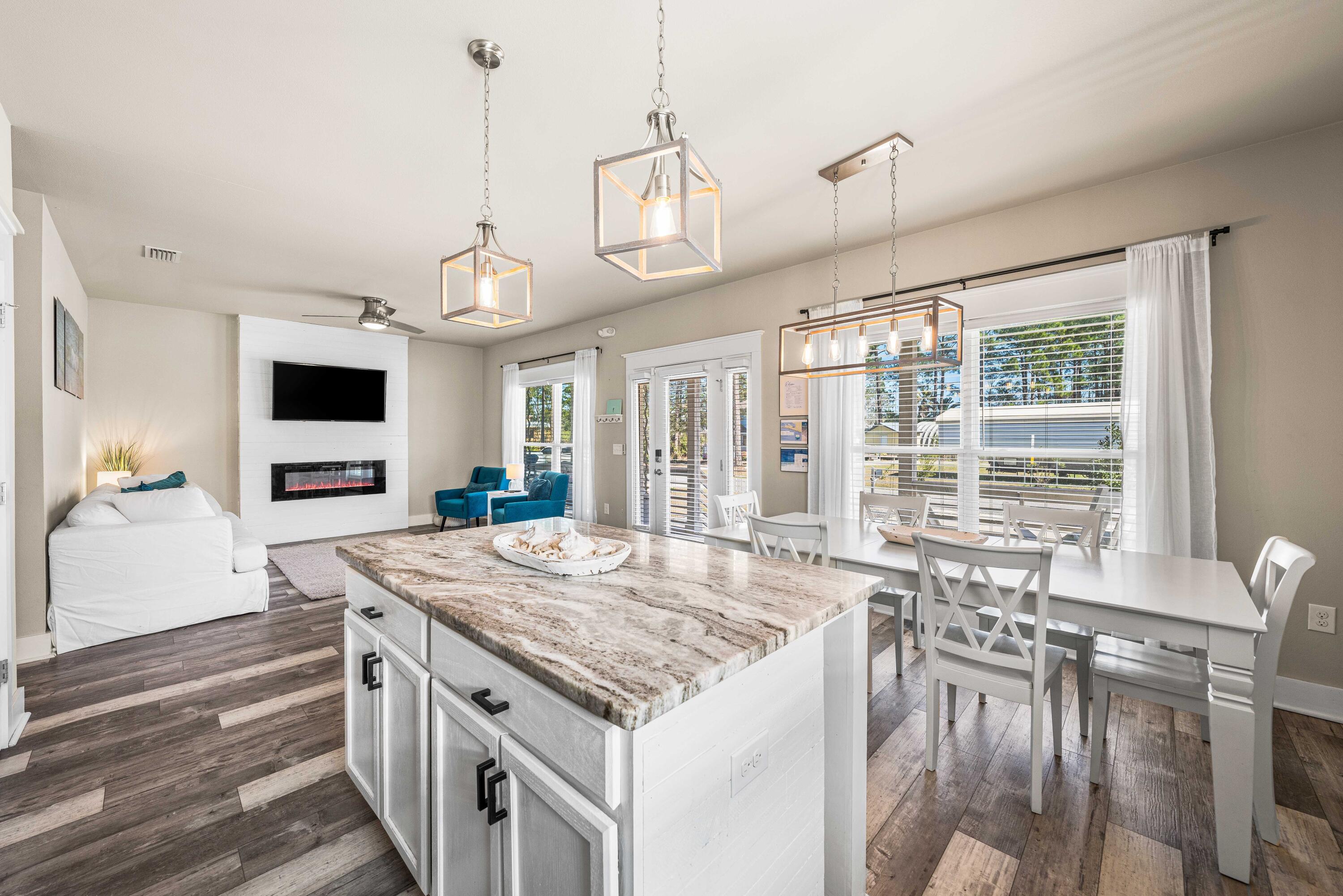 A rare opportunity to step seamlessly into the Santa Rosa Beach lifestyle, this three-bedroom, two-bathroom bungalow offers the flexibility today's buyers crave. Already established as a successful vacation rental with proven income history, it also lives beautifully as a full-time residence or second home near the coast. Built in 2020 and thoughtfully finished from exterior to interior, the home welcomes you with generous double parking and a wide staircase leading to a spacious front porch complete with a custom swing -- the kind of spot made for slow mornings and evening breezes. Inside, soft neutral tones and wide-plank LVP flooring create a relaxed coastal aesthetic throughout the open living, dining and kitchen areas. Granite countertops, coastal gray cabinetry and an attractive backsplash frame a kitchen designed for both everyday living and entertaining. A built-in electric fireplace anchors the main living space with warmth and character while natural light fills the interior. A custom barn door conceals the oversized laundry area and leads to a convenient side exit, keeping daily life practical and organized. Both bathrooms feature beautifully tiled showers that add a polished touch. Out back, the scale is a true standout. The oversized fenced yard offers ample room for gatherings, pets and play -- even future pool plans -- with a spacious deck, pavered walkway and firepit creating an inviting outdoor setting. Whether hosting friends after a beach day or unwinding beneath the stars, this backyard was built for real outdoor living. With no HOA restrictions, flexibility is built in. Public beach access at Ed Walline Regional Beach Access and Blue Mountain Beach is just minutes away, along with 30A dining and shopping. Boating enthusiasts will appreciate being just five minutes from Cessna Landing Boat Ramp, which offers easy access to the bay and open water. For those seeking a smart investment, a great starter home or a coastal retreat with room to grow, this property offers space, style and location in equal measure.
