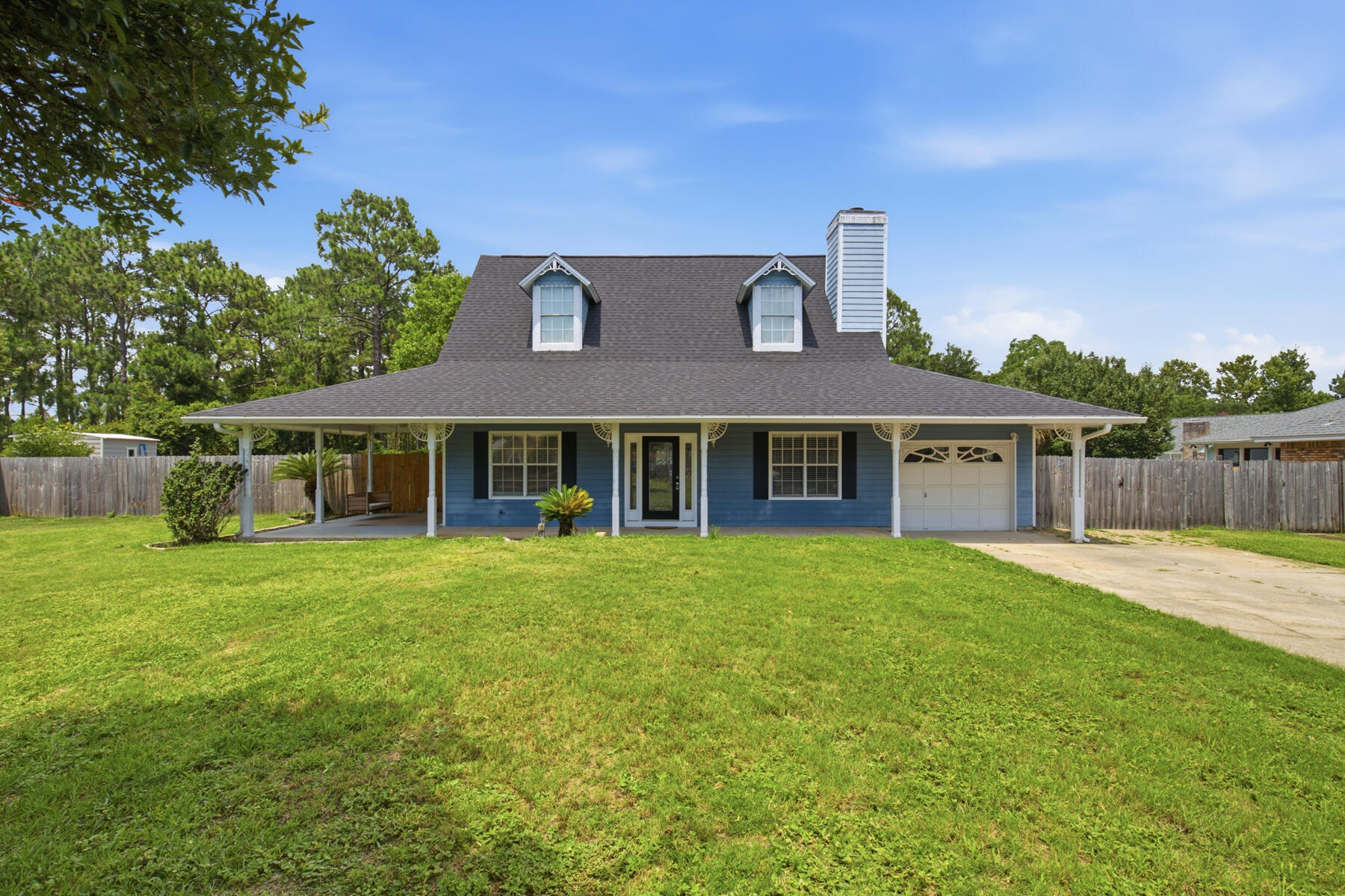 This Cape Cod-style home offers generous space inside and out, conveniently located near military bases and Navarre Beach. Lots of great entertaining space in the large open-concept living room featuring tile flooring, a wood-burning fireplace, and a shiplap accent wall.  The kitchen offers granite countertops and modern pendant lighting over the breakfast bar complete the look. A spacious laundry and mudroom just off the kitchen leads to the backyard. Two bedrooms downstairs provide flexibility for a home office or playroom. Upstairs you'll find new lvp flooring in the master bedroom with two large walk-in closets. Enjoy plenty of natural light with skylights in the master bath as well as a dual vanity with large, tiled shower with dual shower heads. Situated on a half acre lot, the outside has a big wrap around porch perfect for morning coffee on the swing. The extra-large driveway offers plenty of space for boat or RV parking and the property is in ground pool ready as the septic tank has been moved to the front of the home. Multi purpose outdoor garage in back can be used for storing yard tools or turned into a fitness room. This property also comes with a sprinkler system that operates off a well ensuring you'll never worry about a large water bill to keep your yard looking beautiful.  Upstairs you'll find new lvp flooring in the master bedroom with two large walk-in closets. Enjoy plenty of natural light with skylights in the master bath as well as a dual vanity with large, tiled shower with dual shower heads. Situated on a half acre lot, the outside has a big wrap around porch perfect for morning coffee on the swing. The extra-large driveway offers plenty of space for boat or RV parking and the property is in ground pool ready as the septic tank has been moved to the front of the home. Multi purpose outdoor garage in back can be used for storing yard tools or turned into a fitness room. This property also comes with a sprinkler system that operates off a well ensuring you'll never worry about a large water bill to keep your yard looking beautiful.