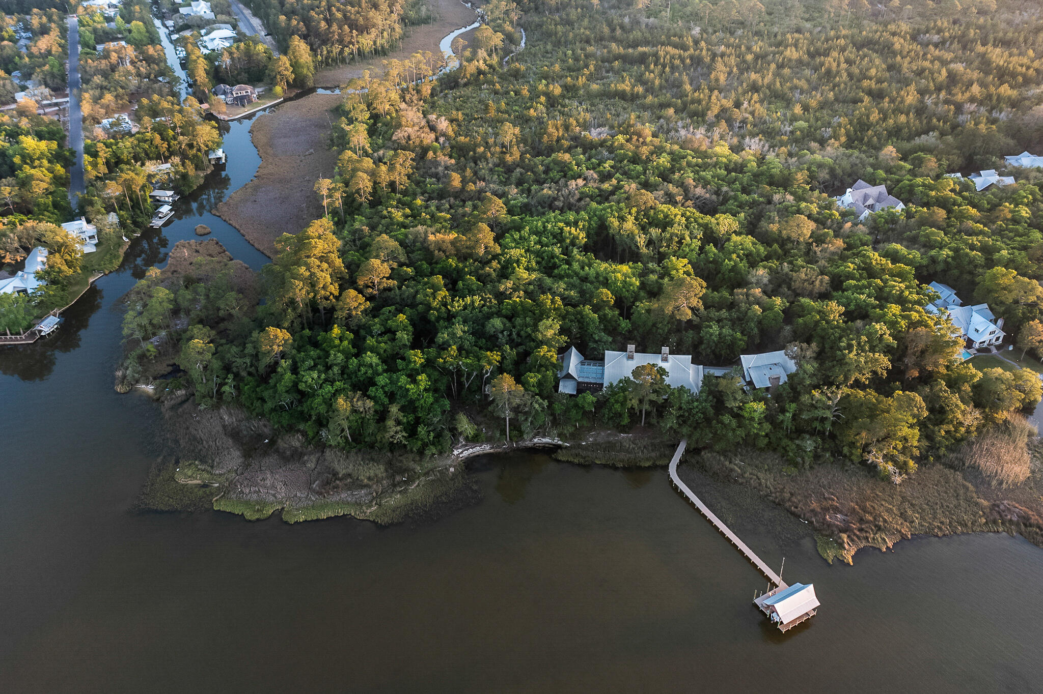 This 5 acre property is only offered for sale together with the contiguous 5.2 acres of vacant land Parcel ID 28-2S-19-24050-012-0010 and will only be sold together. 

In this captivating estate at 442 Nicole Forest Drive, coastal luxury has truly been redefined.  Here, you will not find seashells, starfish or sand dollars. What you will find is a richness that blends Old Florida coastal living with European luxury. This remarkable estate, with breathtaking views of the Choctawhatchee Bay, features over 10 acres of lushly wooded, private bay frontage and almost 8,000 square feet of luxury living space.  The home was designed by Savoie Architects with fixtures, finishes and lighting throughout the home selected by Erika Powell of Urban Grace Interiors, and masterfully constructed by Davis Dunn Construction in 2017. The private estate is comprised of a main house and attached carriage house with four spacious bedrooms, a bunk room, saltwater pool and private dock.

An end-of-the-road cul-de-sac delivers you to the estate's private gate. Upon entering the property, you will find yourself surrounded by massive moss-draped trees of the Point Washington State Forest. An authentic cobblestone driveway meanders to the home's large covered front porch adorned with poplar bark siding, Bevolo gas lanterns, and a solid mahogany front entry door. Through the front door, you will find the elegantly furnished main living and dining area of the home with massive, reclaimed oak beams from a 100-year old Amish dairy barn, reclaimed oak hardwood flooring, two massive, stone masonry, wood-burning fireplaces with gas starters, and 12-foot tall NanaWall folding glass doors opening the space to the expansive outdoor screened porch.

Continuing to the east wing of the home, there is a luxurious guest bedroom with en suite bathroom with heated floors and walk-in closet. Around the corner from the guest bedroom is an elegantly appointed library and sitting area featuring a custom-made antler chandelier, another stone masonry, wood-burning fireplace and large state-of-the art television -- a perfect spot for relaxing, reading or watching movies. 
Beyond the library is a large conservatory replete with glass ceiling, heated brick flooring and recirculating fountain. This room lends itself to additional entertainment space, a quiet meditation room, indoor botany and more.

Nestled in the far east end of the home you will find a luxurious master suite that features a large sitting area, both his and hers dressing rooms, expansive bathroom with heated marble floors and dual vanities, a large jetted tub and steam shower.  Adjacent is a dedicated laundry area, as well as a private office with pecky cypress walls and custom-built Grimes cabinetry featuring a daybed with pull-out trundle.
Spanning the length of the house, folding NanaWall doors take advantage of the unparalleled views of the Choctawhatchee Bay. The massive screened porch has a heated saltwater pool and hot tub, outdoor stone masonry wood-burning fireplace with outside television hidden behind hand-painted storage doors, several seating and dining areas, and a large grilling area. Where you can find the utmost seclusion is on the private boat dock that extends far out into the bay with mullet jumping and redfish lying in wait. The state-of-the-art boat dock is fully equipped with a sealed motors boat lift, including fresh water, electricity, high speed Wi-Fi, Sonos music and security monitoring.

The home's large chef's kitchen features Grimes custom cabinetry and a massive center island topped with Sea Pearl quartzite. Two apron front Shaws porcelain sinks with brass Waterstone faucets offer plenty of room for multiple cooks to operate in this kitchen that feels more reminiscent of an elegant European estate. Featured appliances include a 48" Wolf range, Sub Zero full-size refrigerator and full-size freezer, four Sub Zero beverage refrigeration drawers, 2 Sub Zero wine coolers, and a Sub Zero warming drawer in the island. Add to this, NanaWall folding glass pass-thru windows that open from the kitchen to the outdoor grilling area of the side porch which features 2 Big Green Eggs, DCS plumbed gas grill, flat top griddle and an outdoor porch sink. 
Adjacent to the kitchen, a charming butler's pantry, large enough to be a small kitchen, has ample cabinet and shelving space for pots and pans and pantry items as well as an additional drop-in Kohler sink and Wolf microwave.

The house boasts an enormous laundry room with an abundance of linen storage, as well as a half bathroom, and a mud room with more Grimes cabinetry for storage and a commercial ice maker. Exiting the mud room, you're led to the screened breezeway with access to the 3-car garage and carriage house.
The carriage house boasts almost 1600 square feet of additional living and guest space. On the ground floor, a large hobby room features a stone masonry, wood burning fireplace and captivating views of the bay.  Upstairs, the carriage house accommodations include a full kitchen, two bedrooms with en suite bathrooms, a four-bed bunk room, and full-size laundry facilities. The screened porch, which is accessible through NanaWall glass doors, features another wood-burning fireplace and views of the bay.

Whole house systems include Control4 system with dimmable LED lighting, sound system and state-of-the-art security system, as well as high-speed fiber optic internet service, 70 kW whole-home generator, and Rinnai instant hot water system.

There is not another property on Choctawatchee Bay that compares to 442 Nicole Forest Drive. This is a rare opportunity to enjoy unprecedented richness, privacy and splendor with Old Florida vibes. Call today for your private showing.