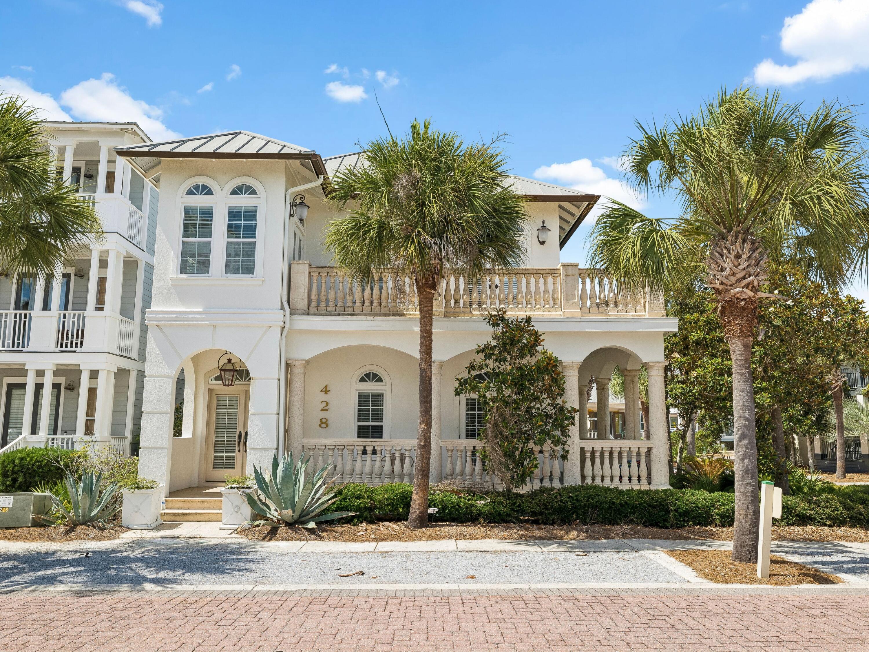 A stately coastal retreat where timeless Mediterranean elegance meets effortless beachside living in the heart of Seacrest Beach. Offering four bedrooms and four baths across two gracious stories, this residence is wrapped in soft white stucco beneath a standing-seam metal roof, captivating from the curb with its arched colonnade, hand-finished stone balustrades, and a canopy of swaying palms. Step inside to sun-filled living spaces defined by soaring ceilings, arched transom windows, and warm hardwood floors. At the heart of the home, a gourmet kitchen dazzles with crisp white cabinetry, a sculptural marble waterfall island, and a shimmering crystal chandelier. A coveted main-floor primary suite offers single-level convenience and privacy, complete with a spa-inspired bath. Three additional well-appointed bedrooms offer serene retreats, while four spa-inspired baths showcase marble vanities, deep soaking tubs, and refined designer fixtures. An additional flex space, thoughtfully configured as a sleeping room, enhances the home's accommodation capacity and is currently utilized as a fifth sleeping area for rental purposes. Tiled balconies and a gracious covered loggia blur the line between indoors and out -- perfect for morning coffee or sunset gatherings.

A proven income producer, this residence grossed $141,000 in rental revenue in 2025 and is projected to reach $162,000 this year -- a testament to its enduring appeal and strong earning potential. Beyond the residence itself, the generously proportioned homesite presents a rare opportunity for future enhancement, with space suitable for a private pool, carriage house, or both, subject to applicable approvals.

Set within one of 30A's most coveted communities, Seacrest Beach offers an unrivaled resort lifestyle anchored by its legendary 12,000-square-foot lagoon pool -- one of the largest in Florida -- complete with cascading waterfalls, a fountain, children's splash area, and poolside snack bar. Residents enjoy seasonal tram service to the sugar-white sand, deeded beach access, more than a mile of shaded walking trails, and a grassy amphitheater hosting concerts and festivals year-round. Just minutes from the boutiques and dining of Rosemary Beach and Alys Beach, 428 Beach Bike Way is a rare harmony of sophistication, comfort, and coastal charm -- Emerald Coast living at its very finest.